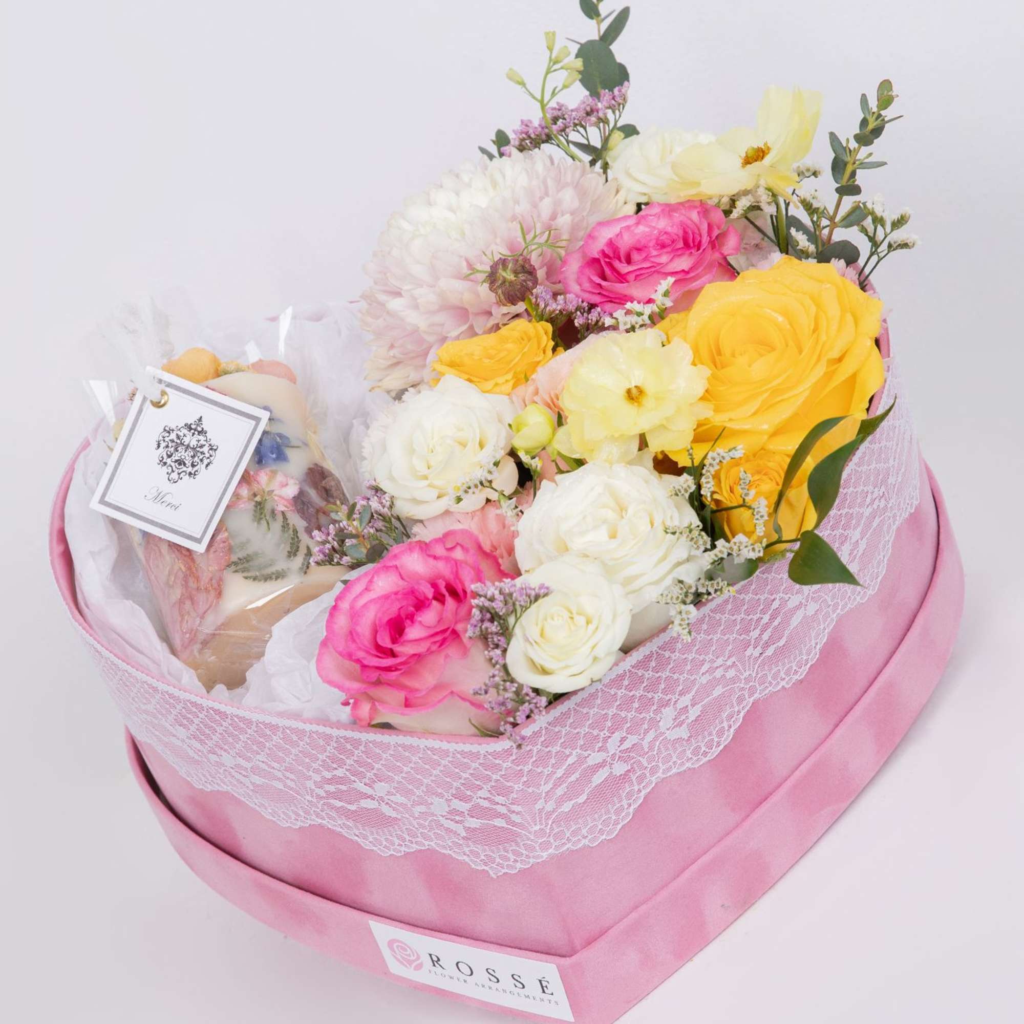 A romantic heart-shaped box filled with pastel roses and seasonal blooms, paired