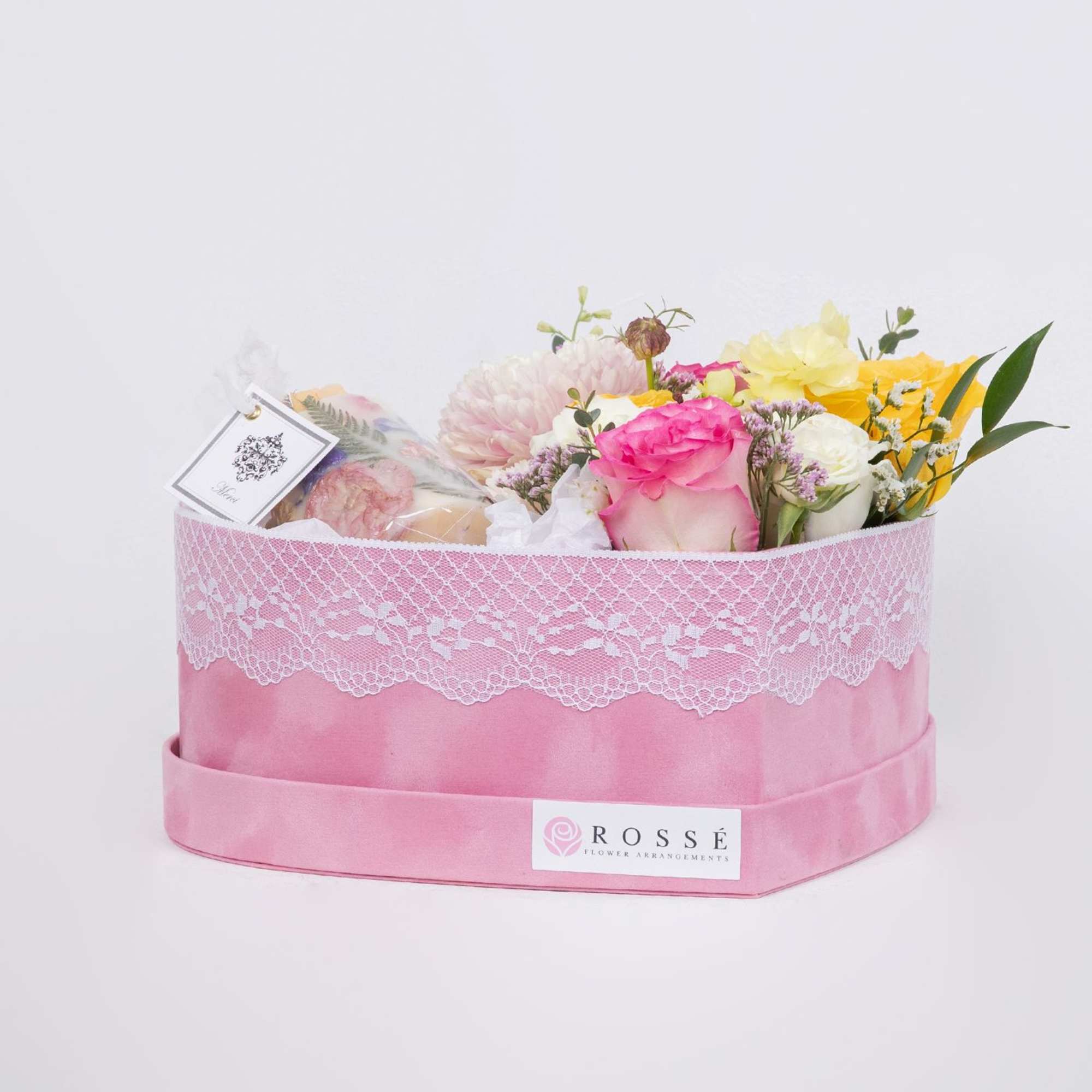 A romantic heart-shaped box filled with pastel roses and seasonal blooms, paired