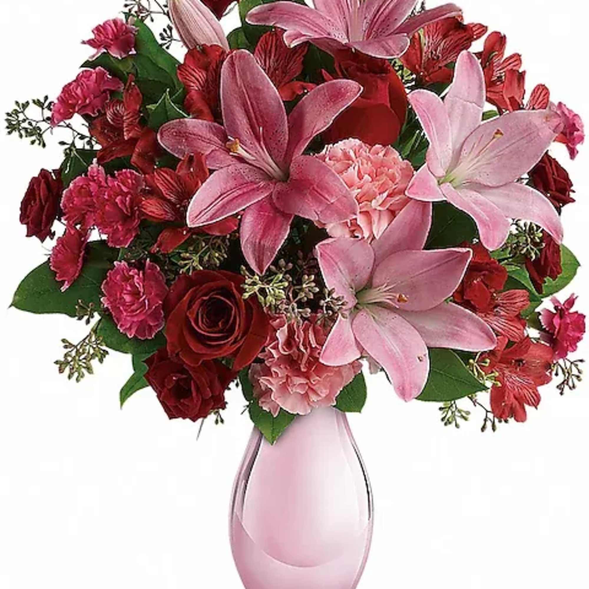 Pink and red bouquet with lilies and roses in a pink glass vase
