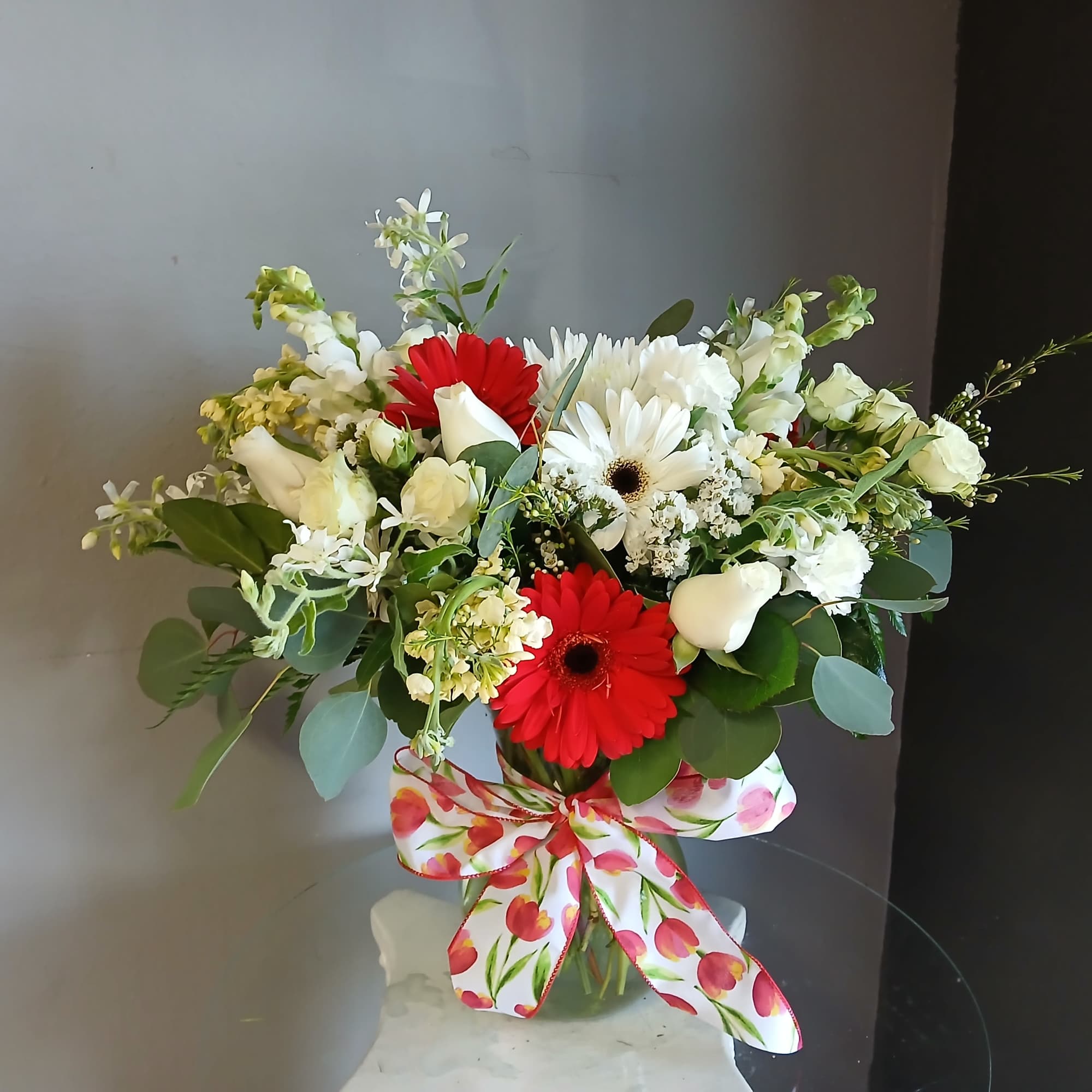 This beautiful flower arrangement of fresh mixed seasonal blooms is made by