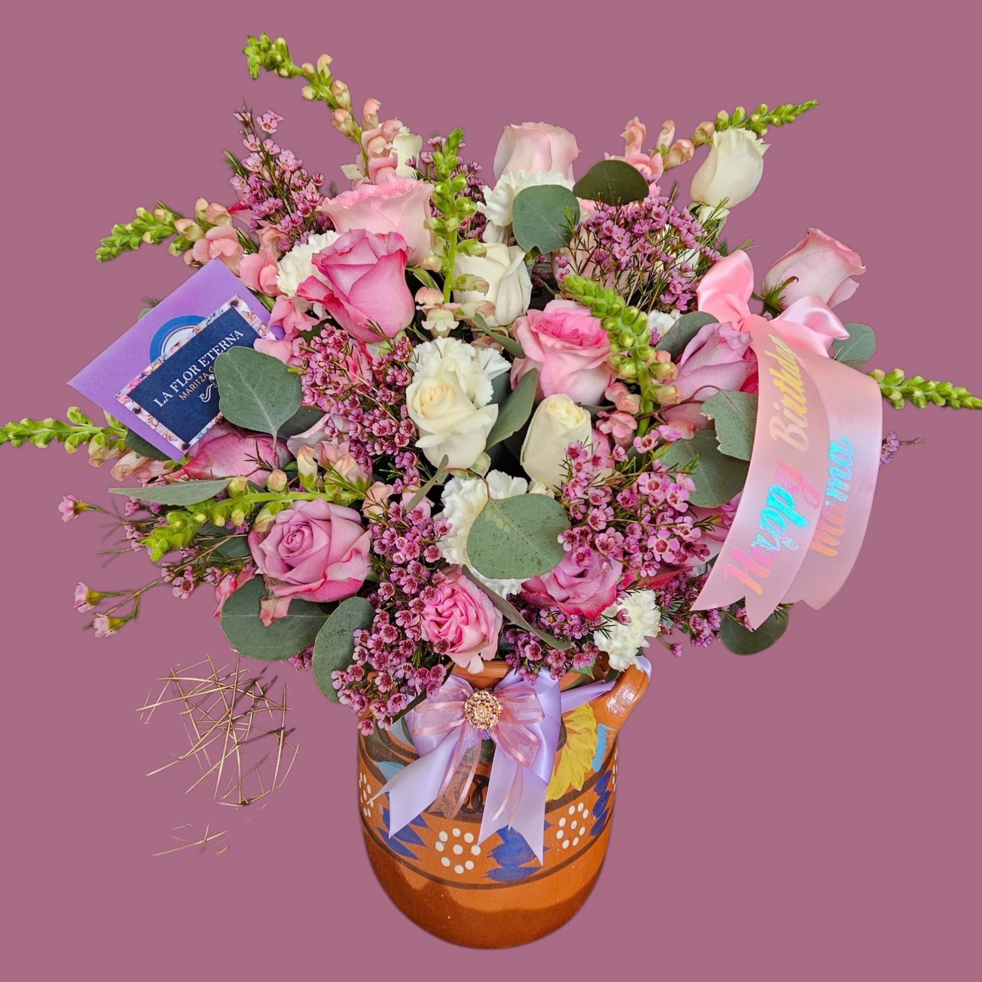 A soft, rounded bouquet of pink and peach roses accented with tall