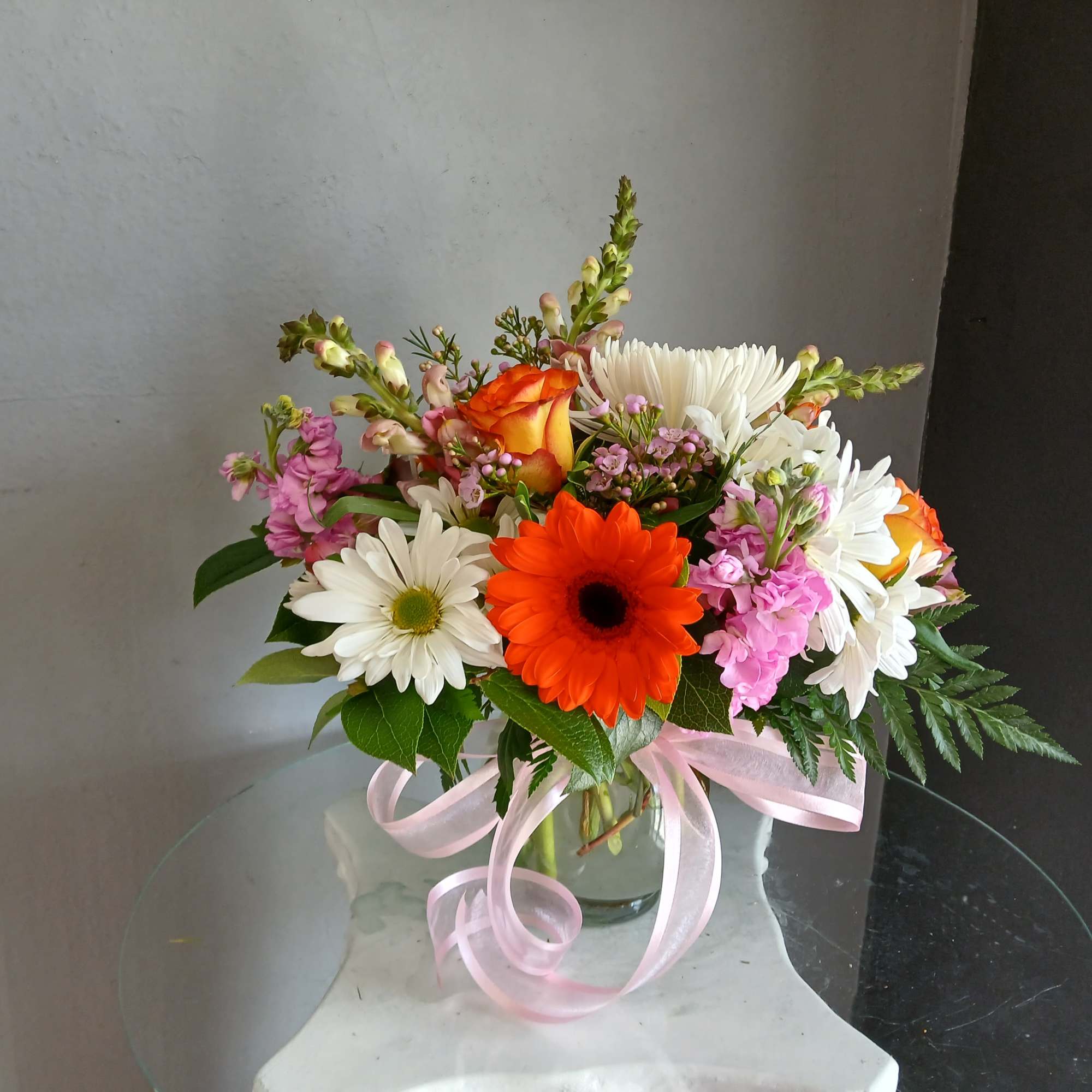 This beautiful flower arrangement of fresh mixed seasonal blooms is made by