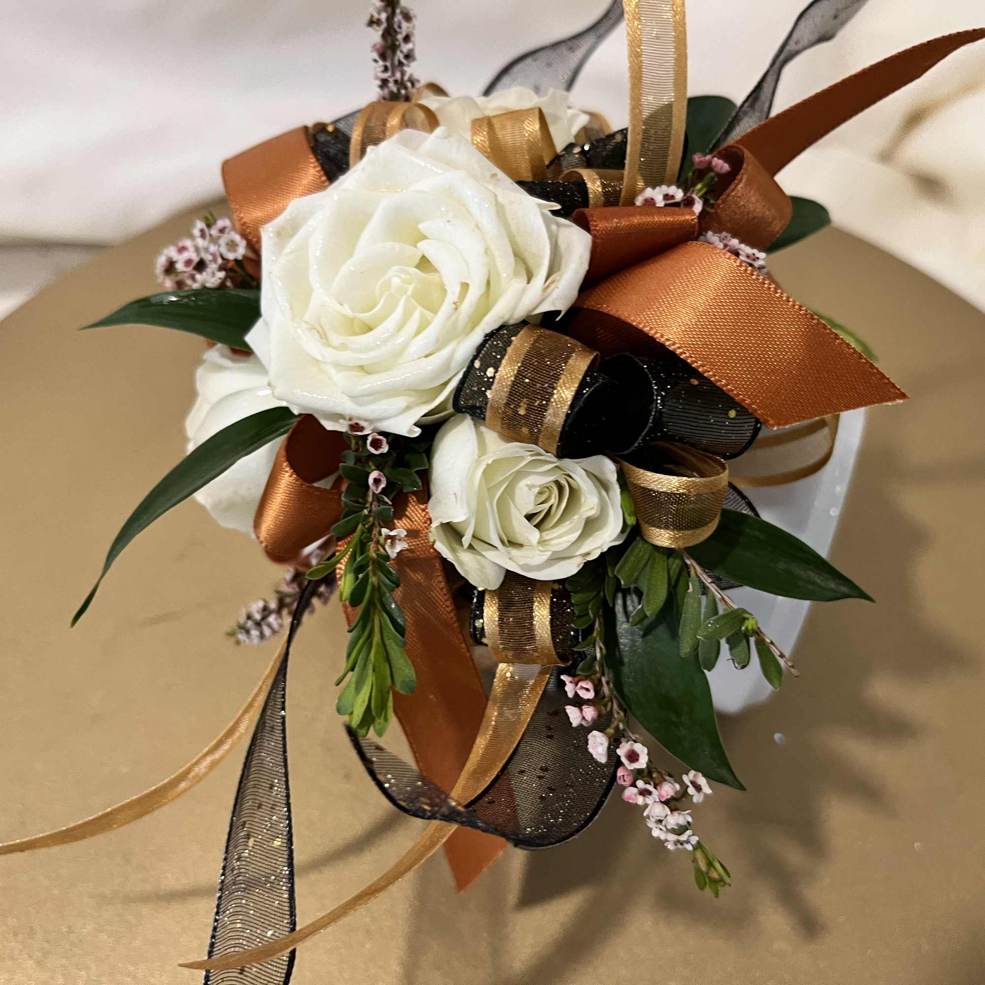 White rose corsage with orange and black ribbon accents