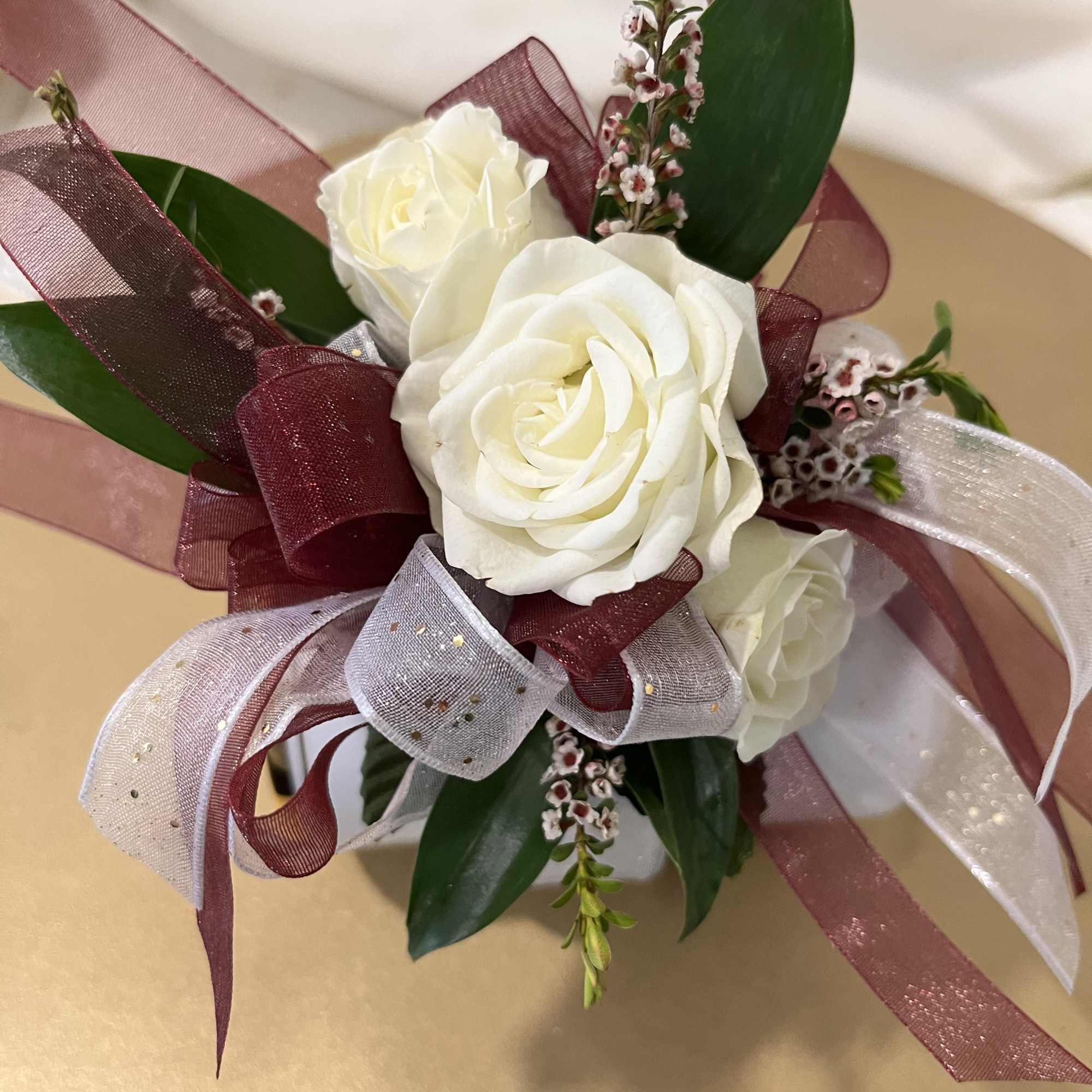 White rose bouquet with burgundy and silver ribbon accents