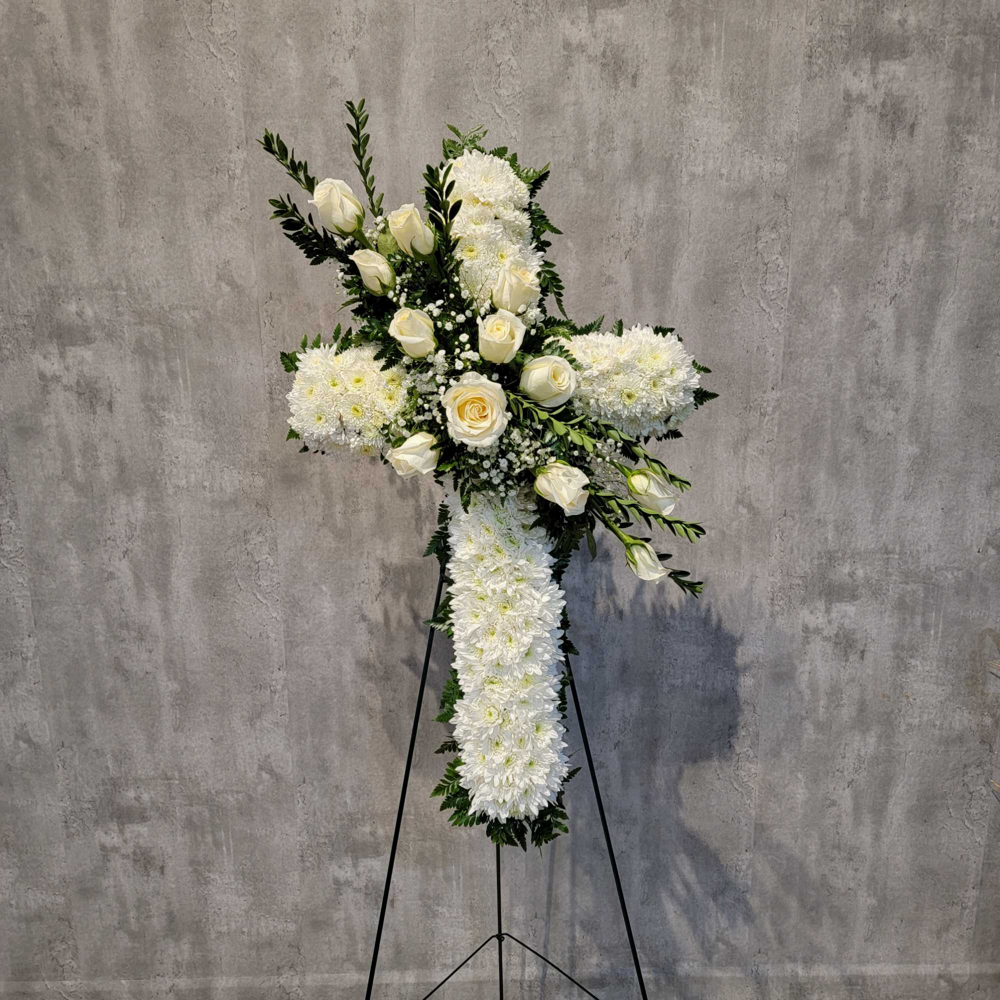 White floral cross on a black stand