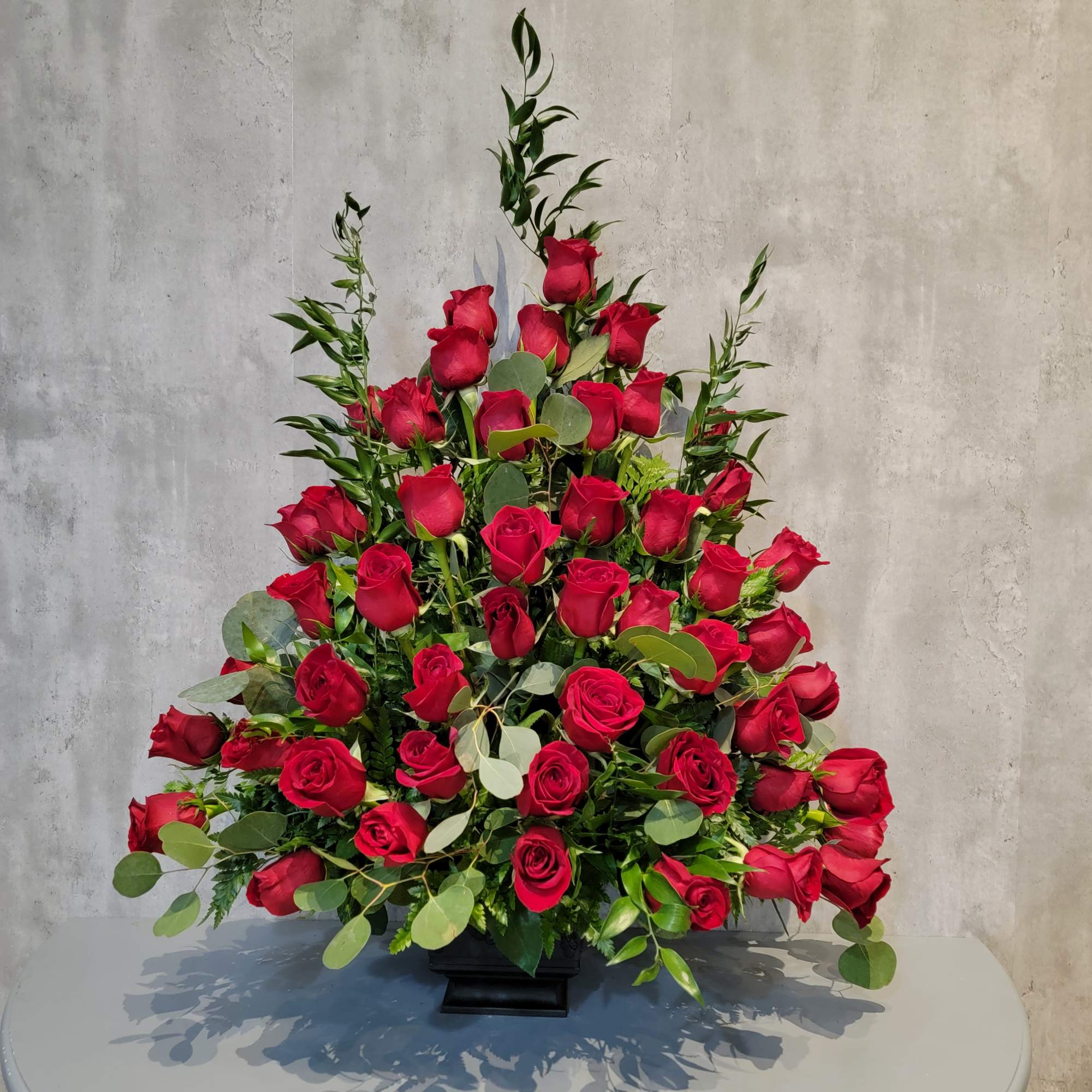 Large arrangement of red roses in a black vase