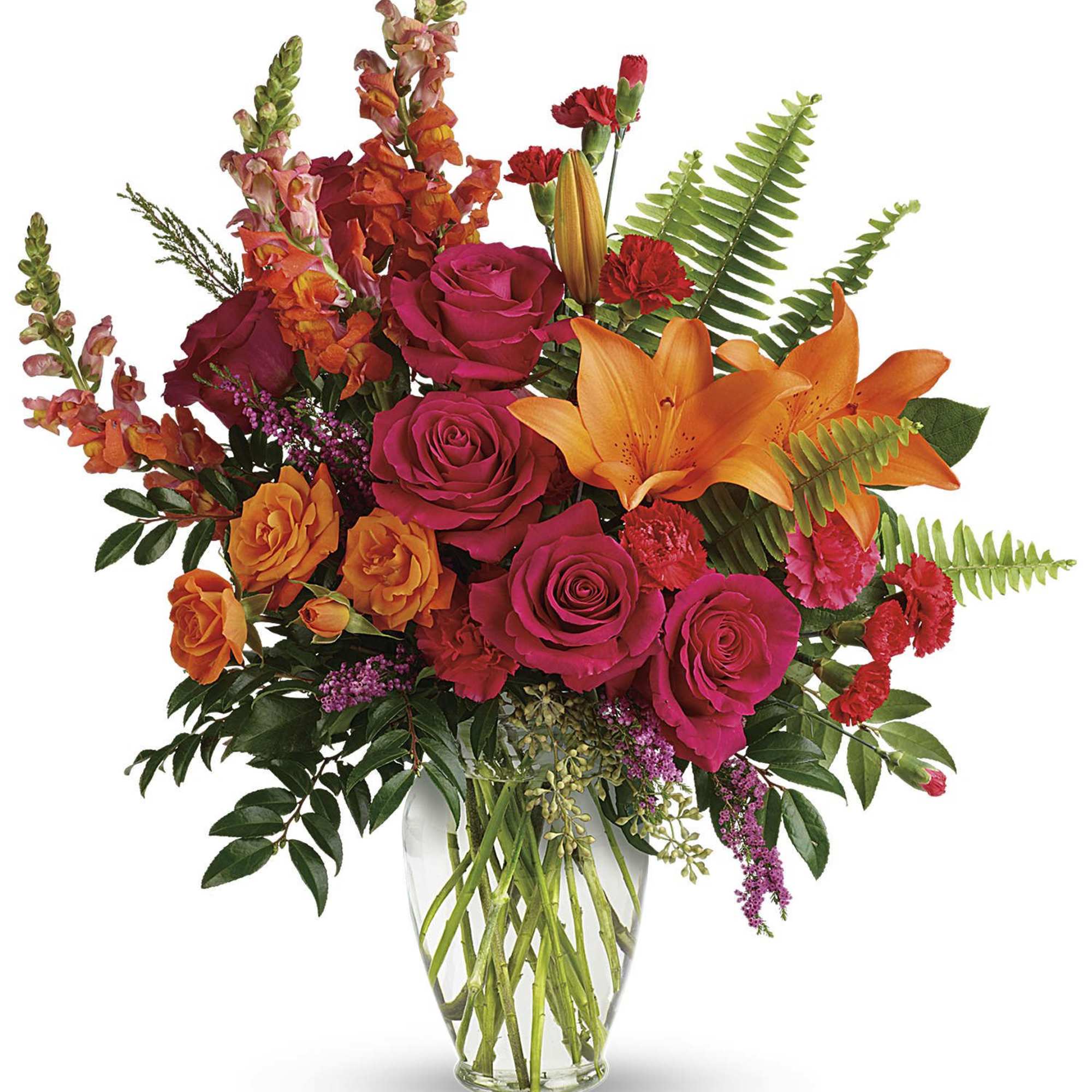 Bright mixed bouquet of roses, lilies, and snapdragons in a clear glass vase