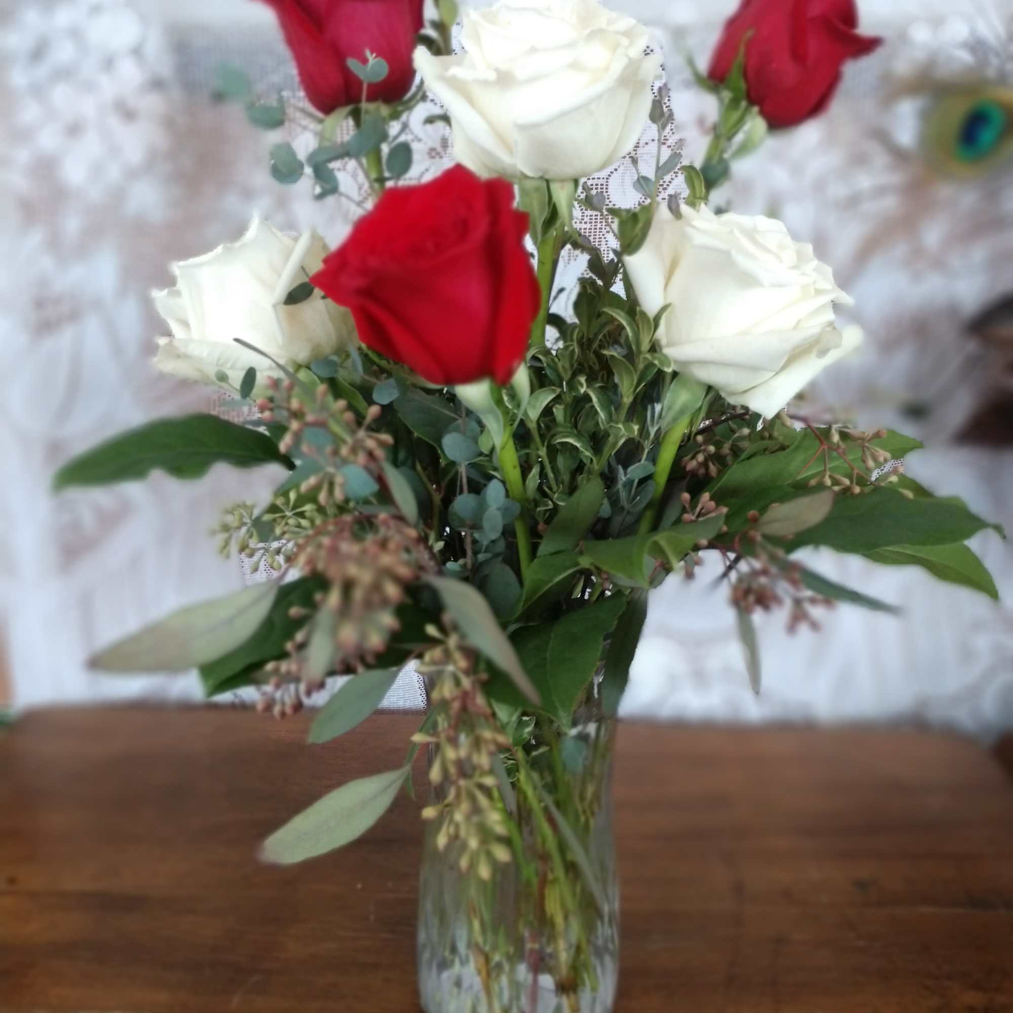 Red and white roses arranged in a clear glass vase