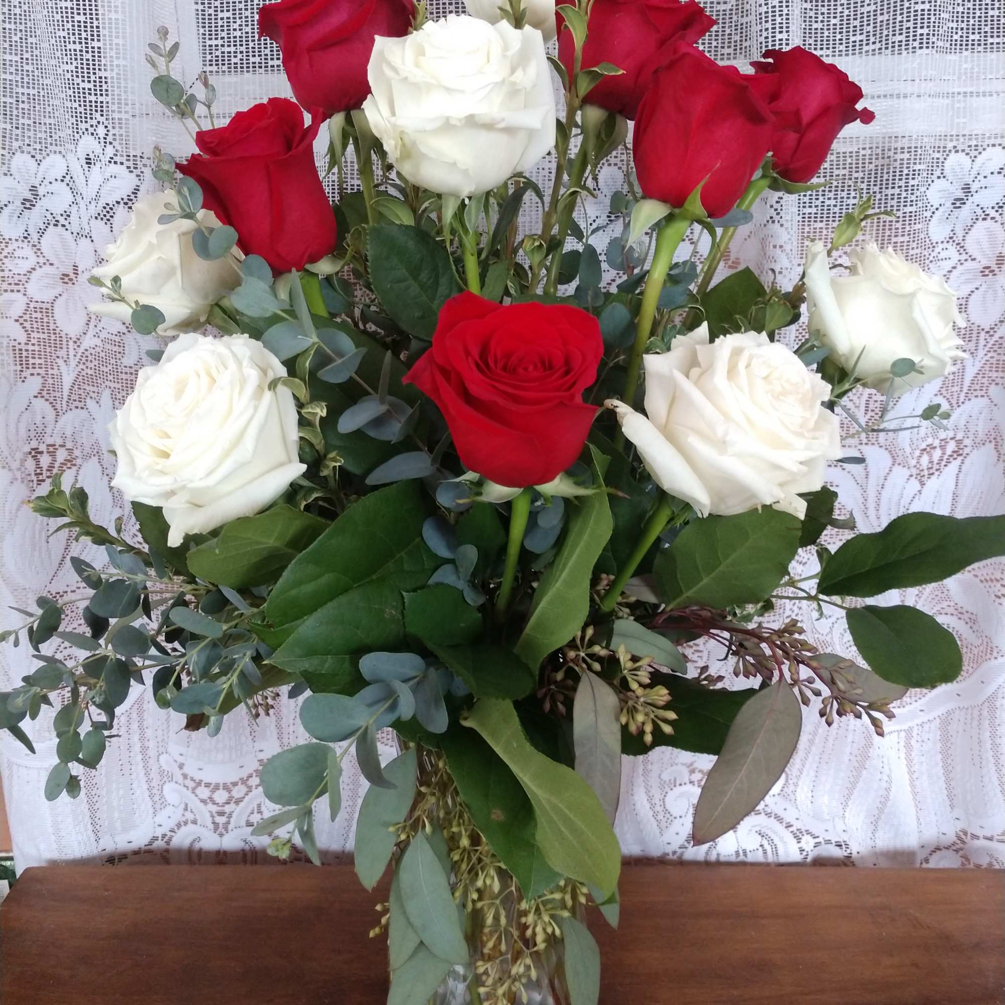 Red and white roses arranged in a clear glass vase