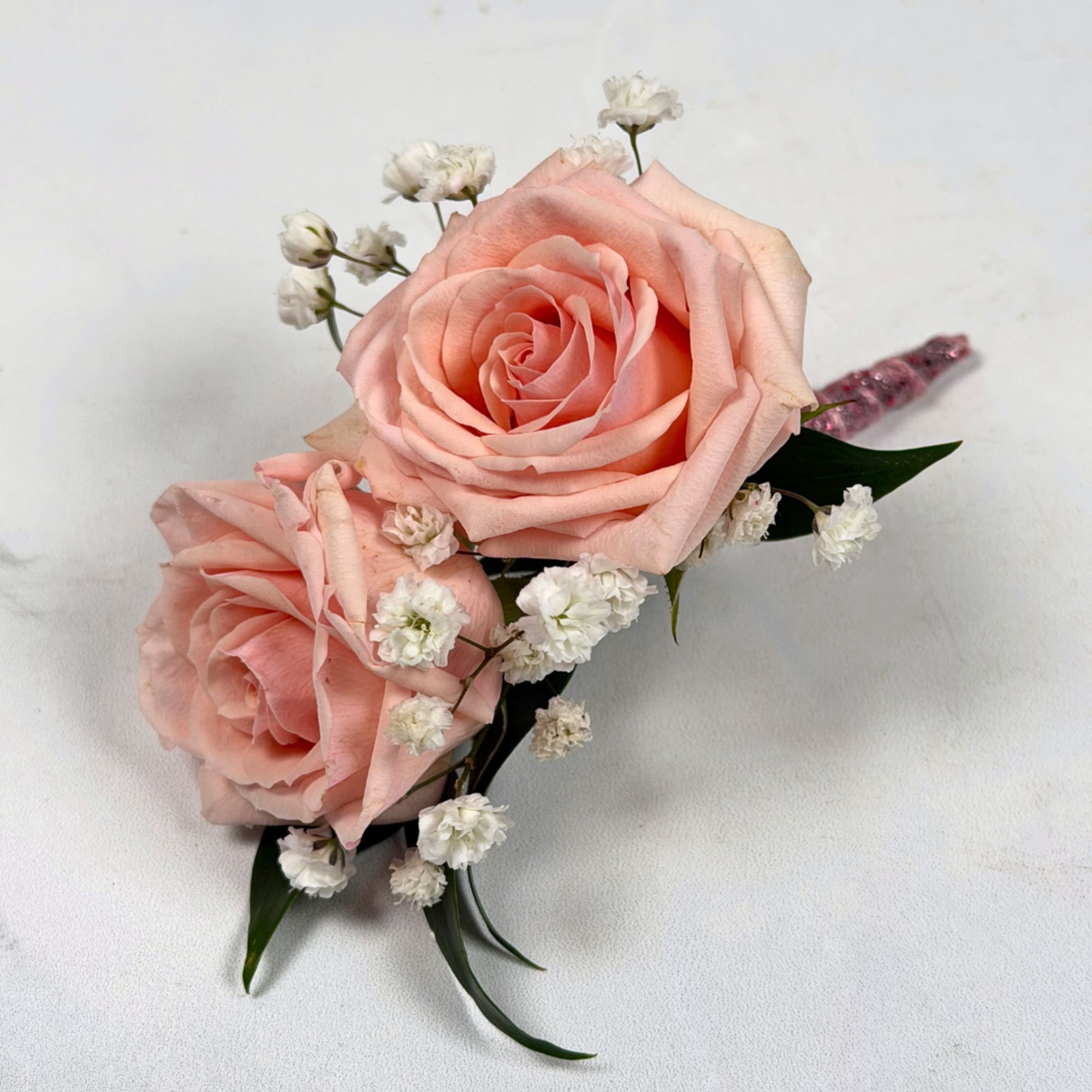 Two pale blush roses sit snugly together in this Rose Quartz boutonniere