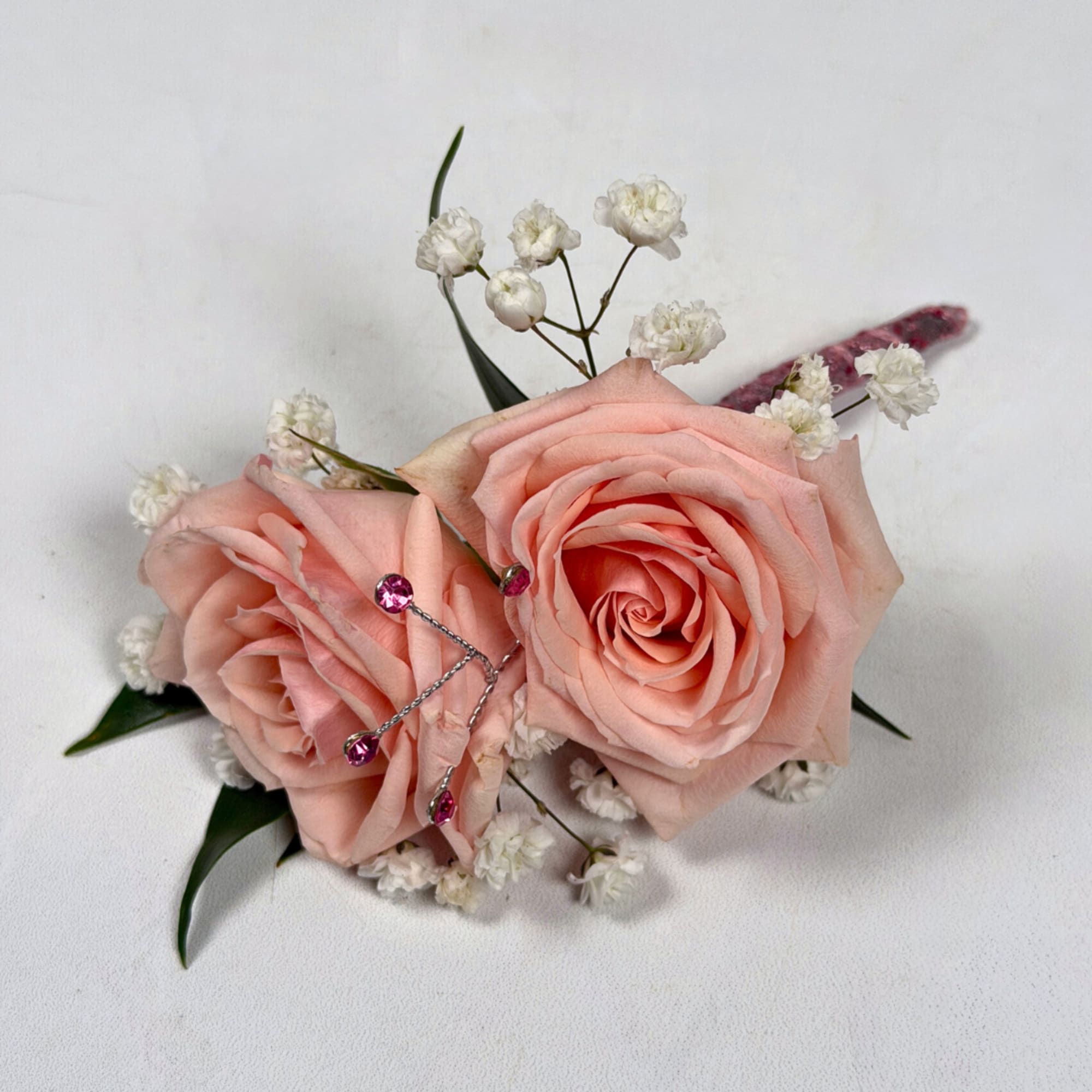 Two pale blush roses sit snugly together in this Rose Quartz boutonniere