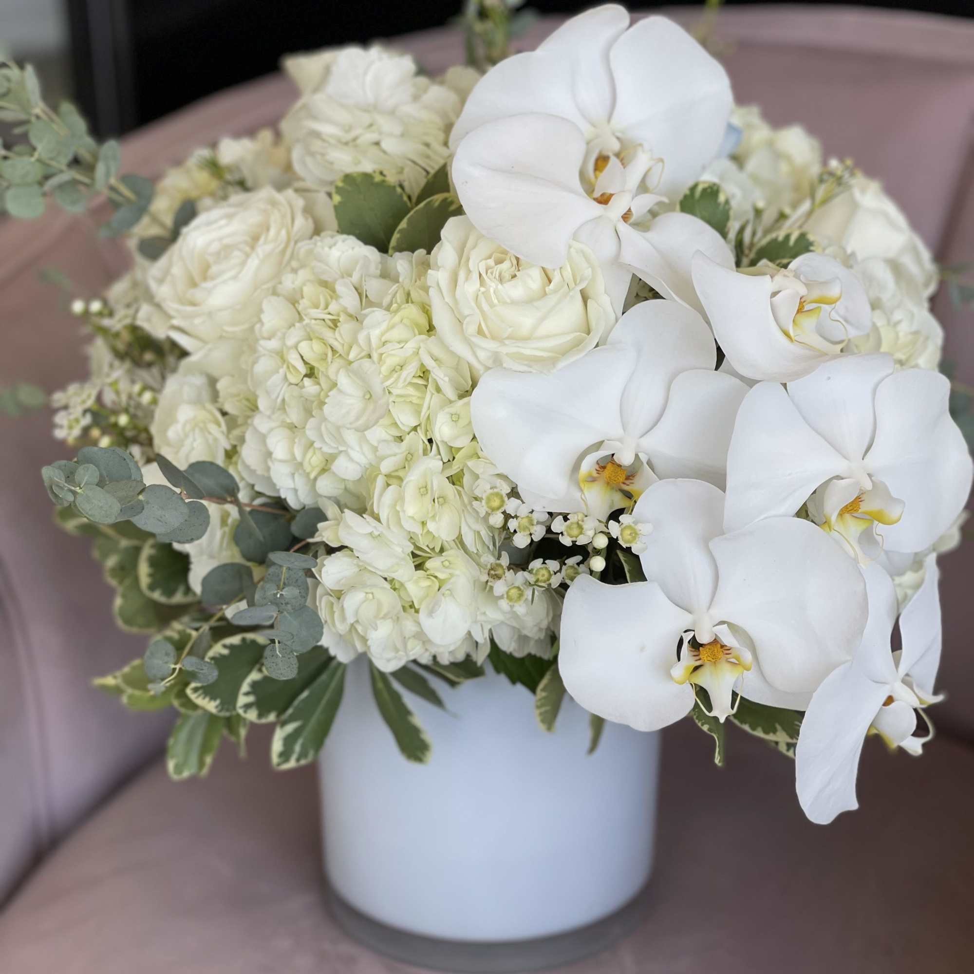 White orchid and rose arrangement in a white vase