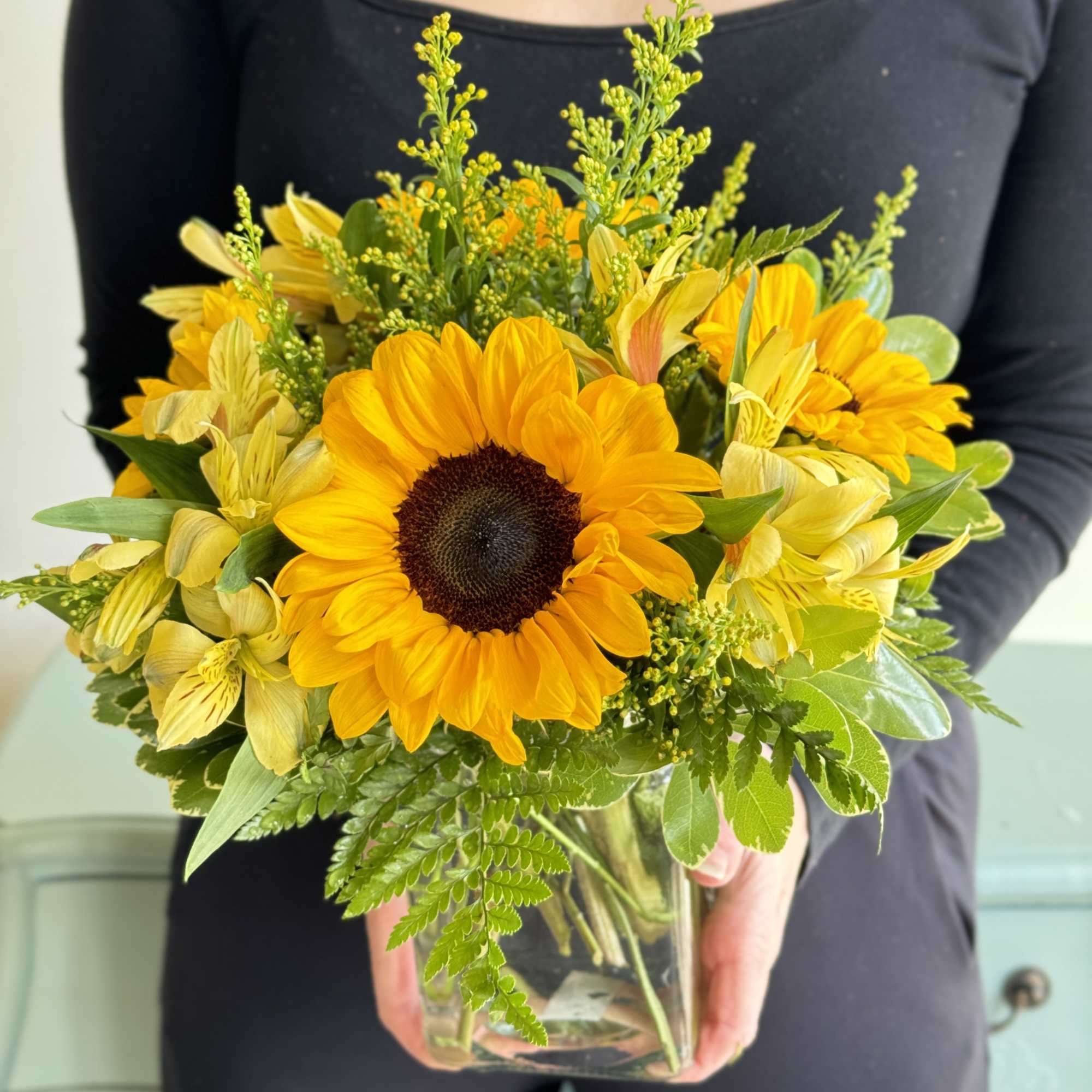 Brighten someone&rsquo;s day with bright yellow sunflowers accented with solidago and arranged