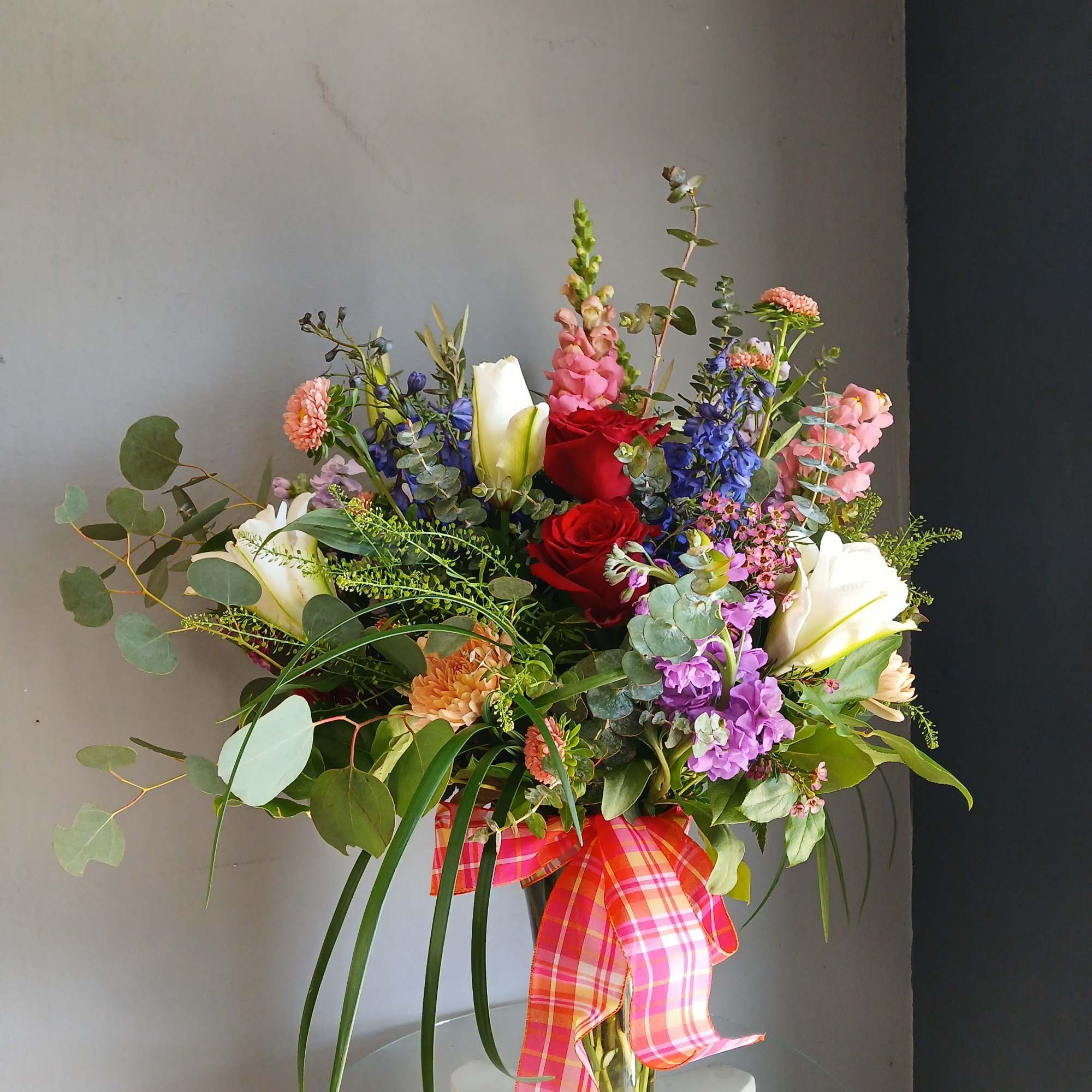 This beautiful flower arrangement of fresh mixed seasonal blooms is made by