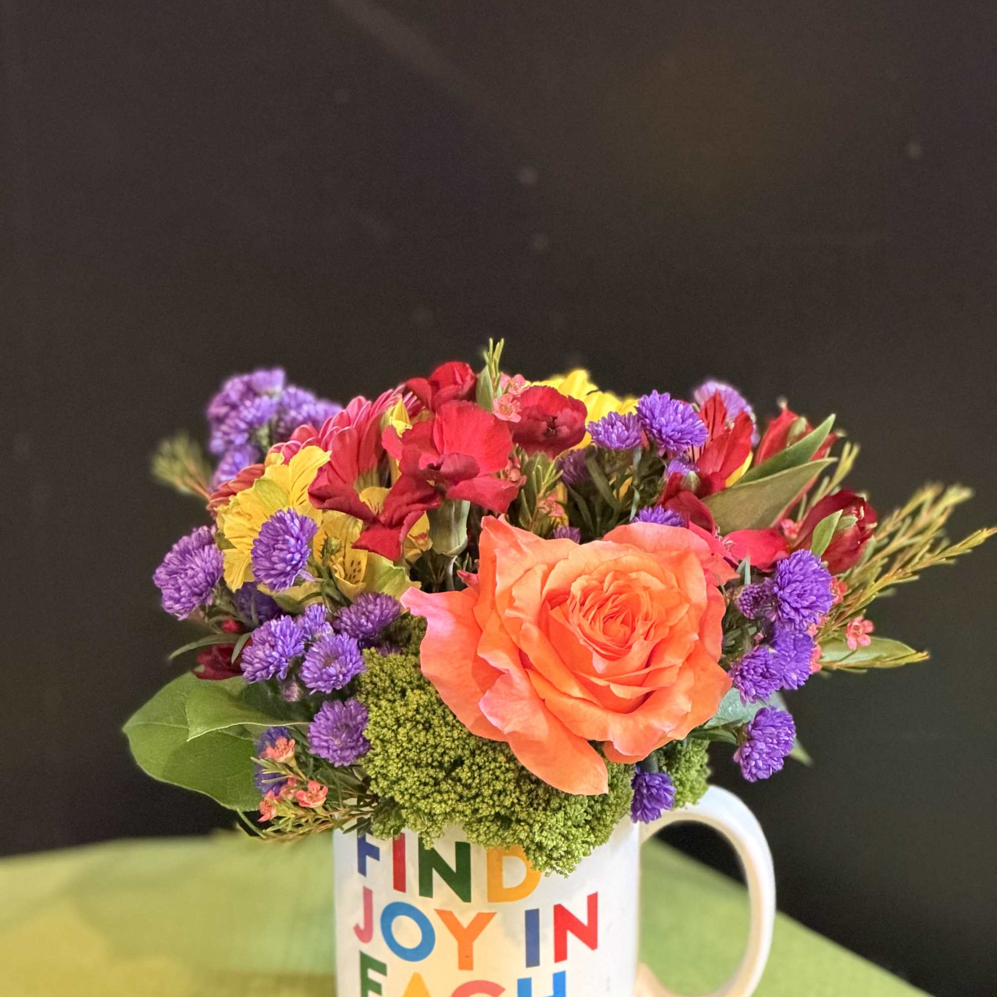 A cheerful floral arrangement featuring a vibrant mix of seasonal blooms, beautifully