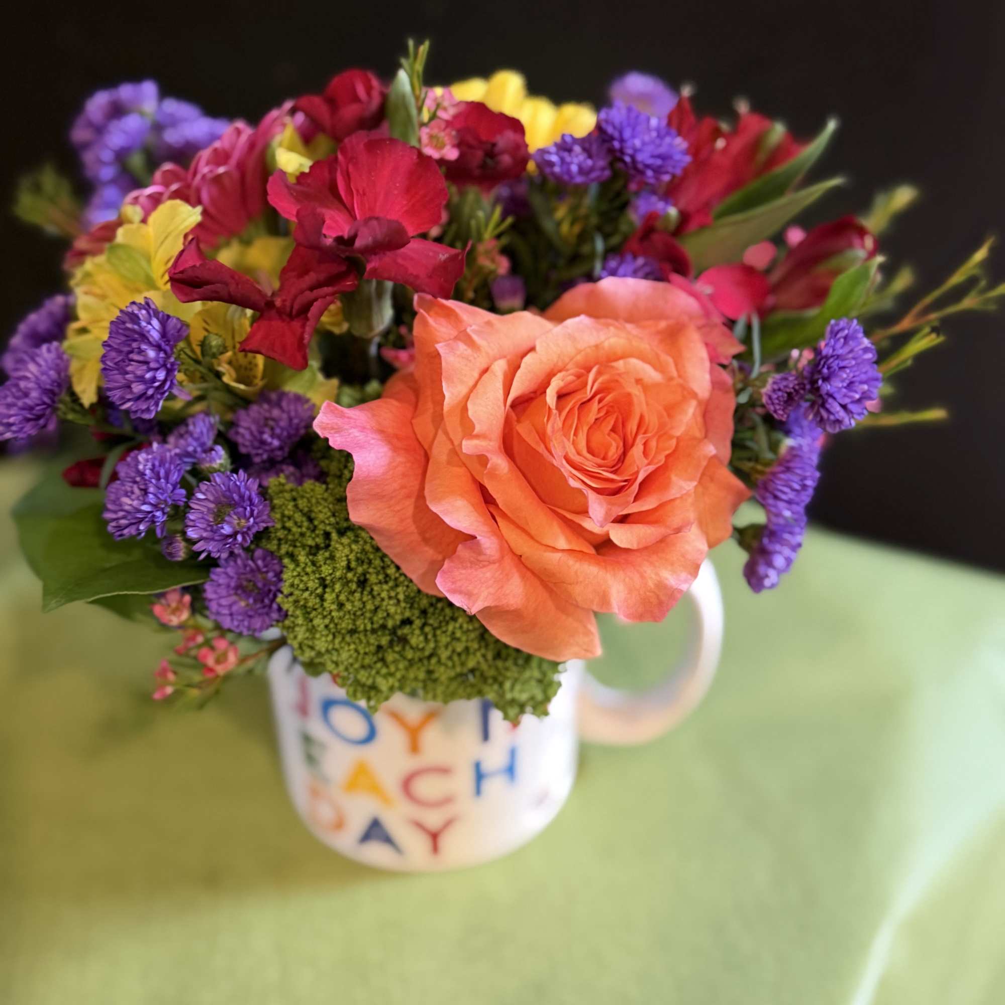 A cheerful floral arrangement featuring a vibrant mix of seasonal blooms, beautifully