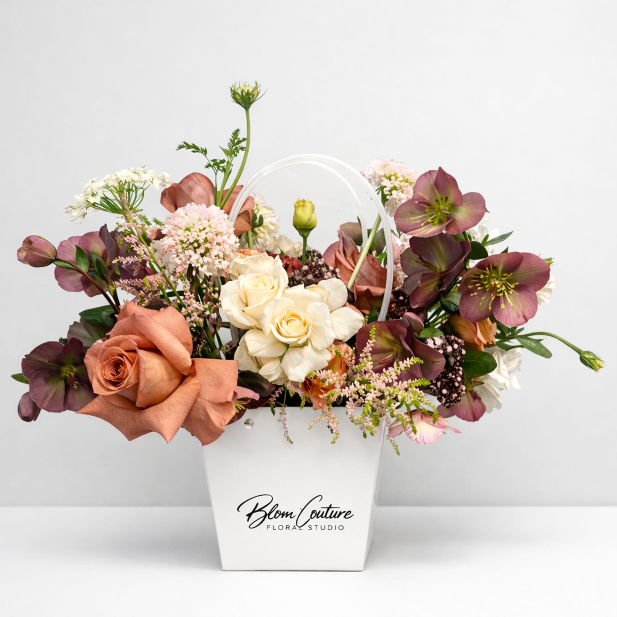 This arrangement blends soft romance with rich, moody tones. Cream and dusty-pink