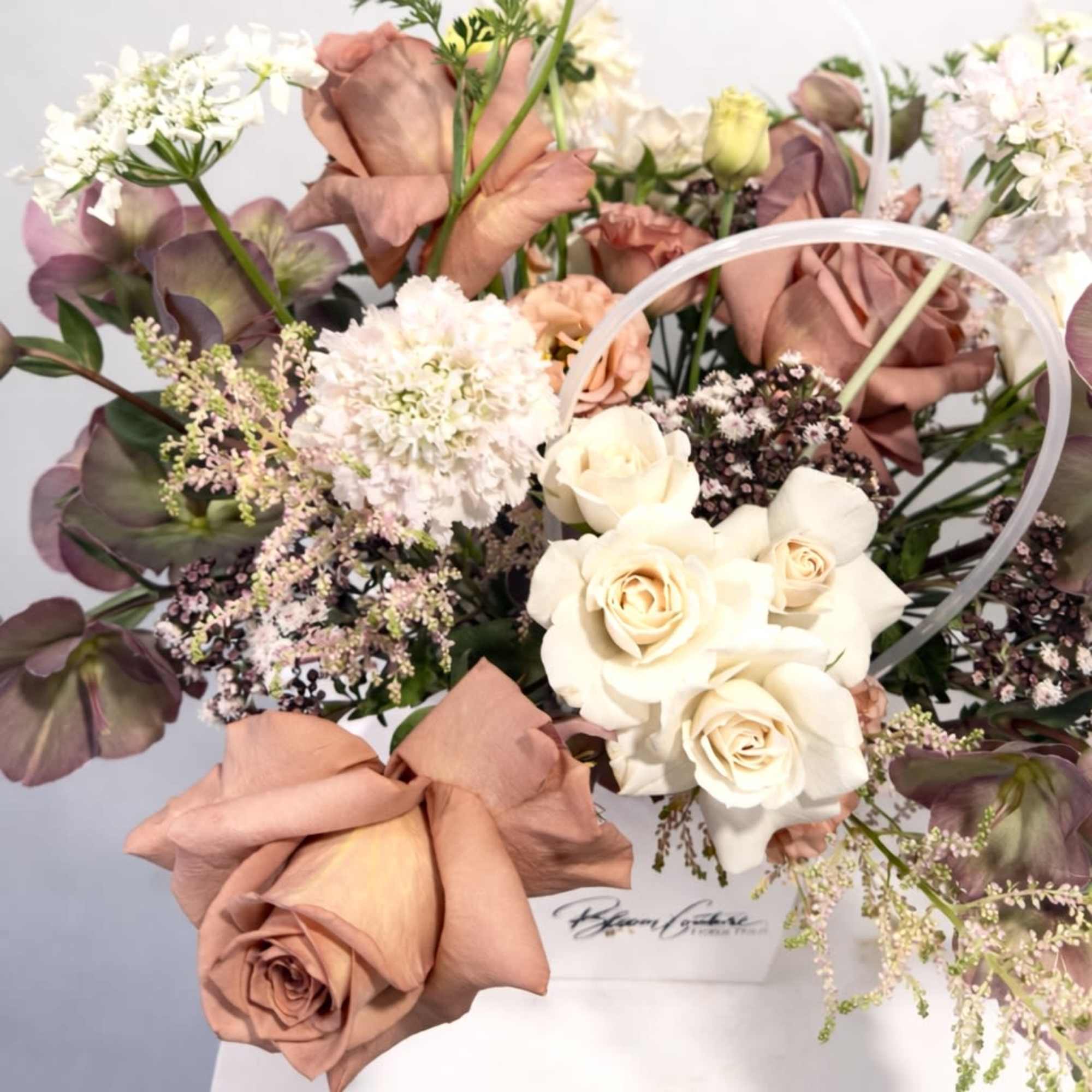 This arrangement blends soft romance with rich, moody tones. Cream and dusty-pink