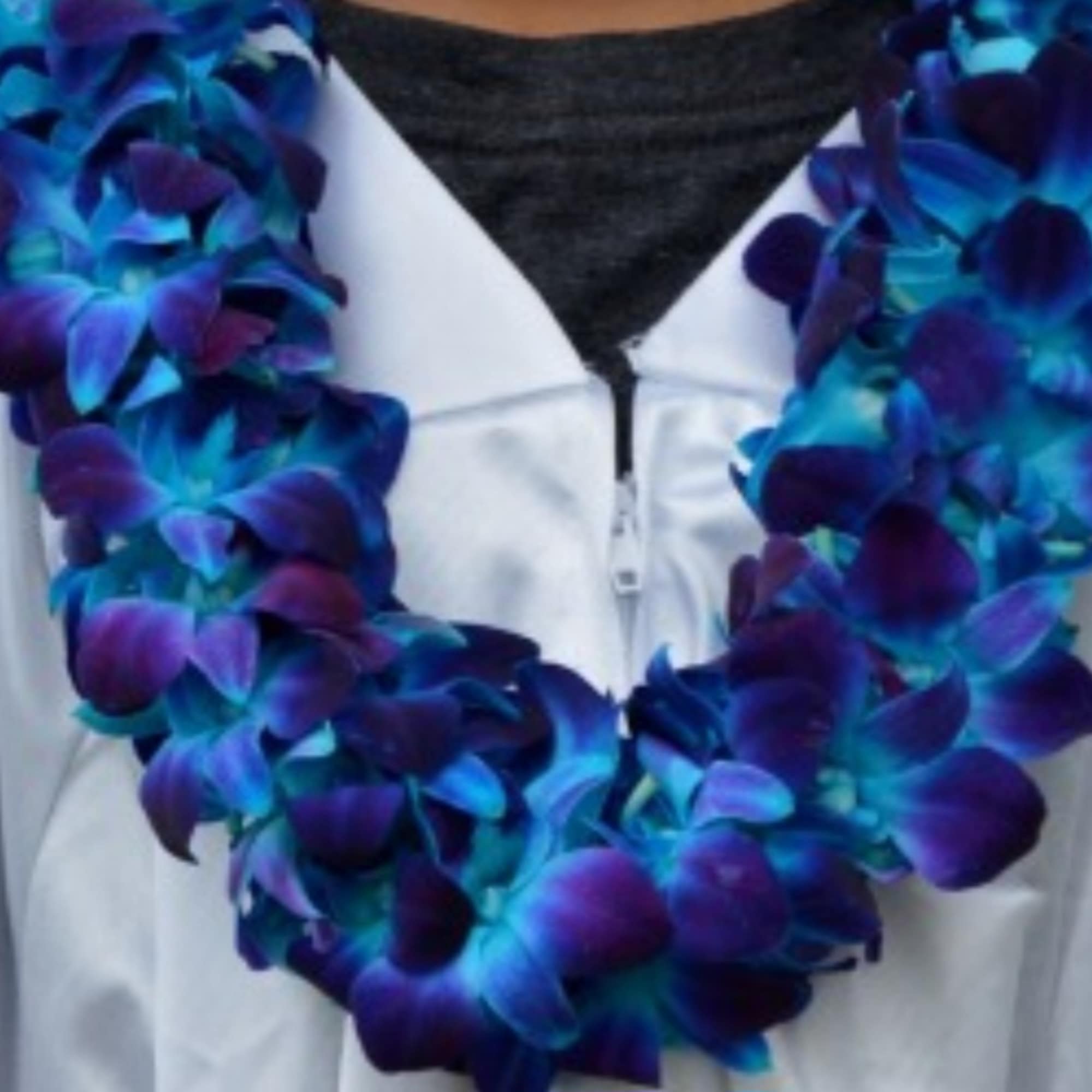 Blue and purple flower lei draped over a white jacket