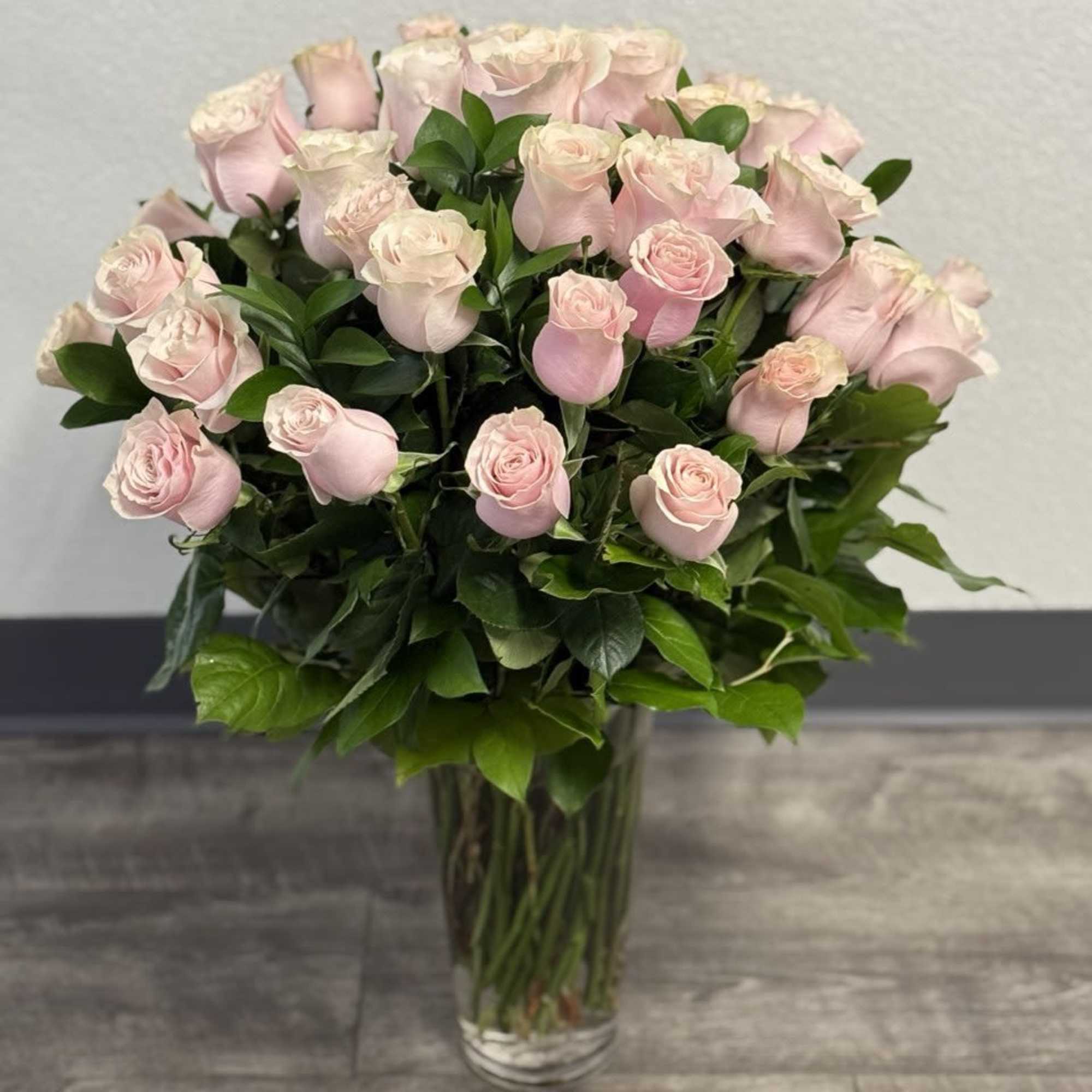 Bouquet of pale pink roses in a clear glass vase