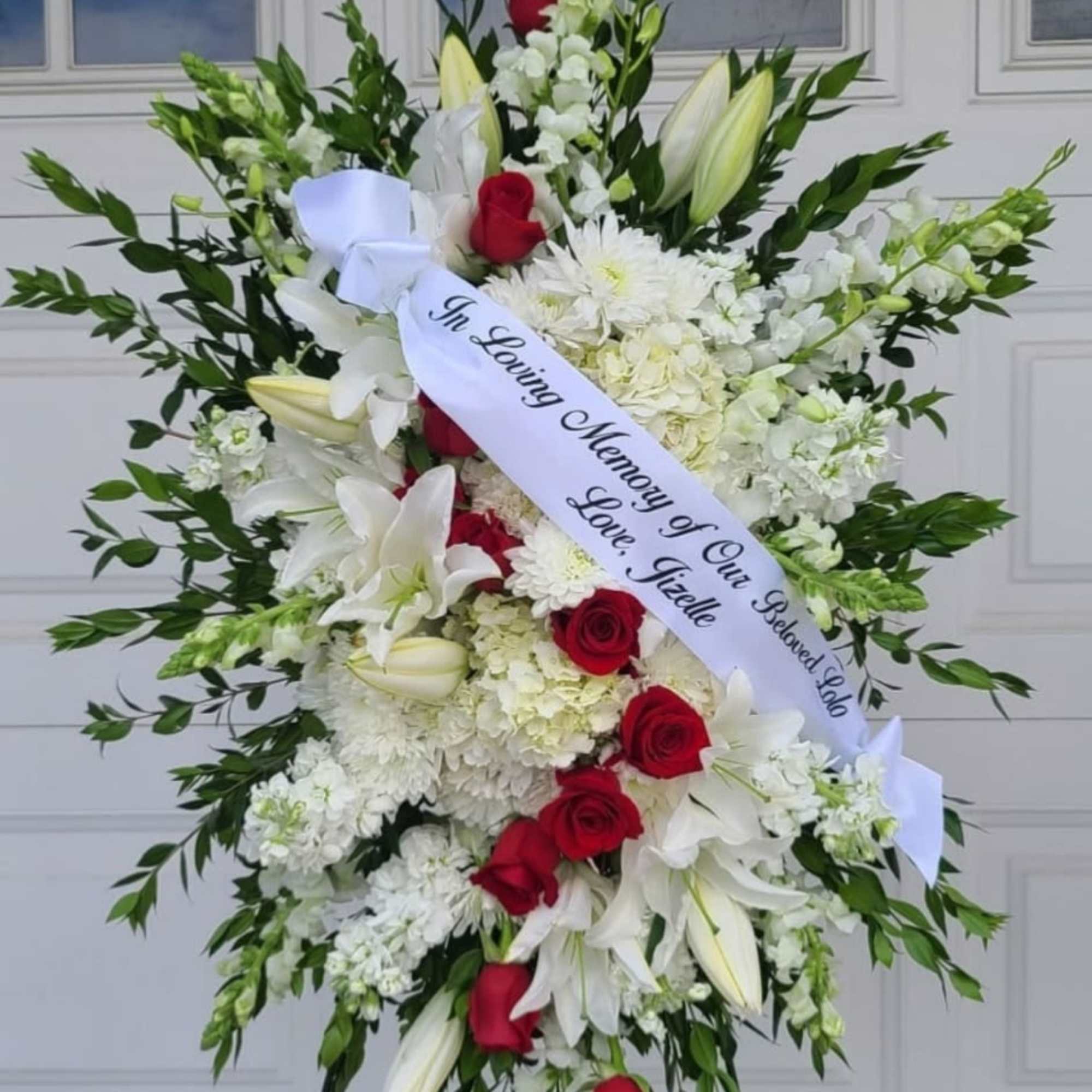 A formal standing sympathy spray that speaks with quiet dignity, arranged for