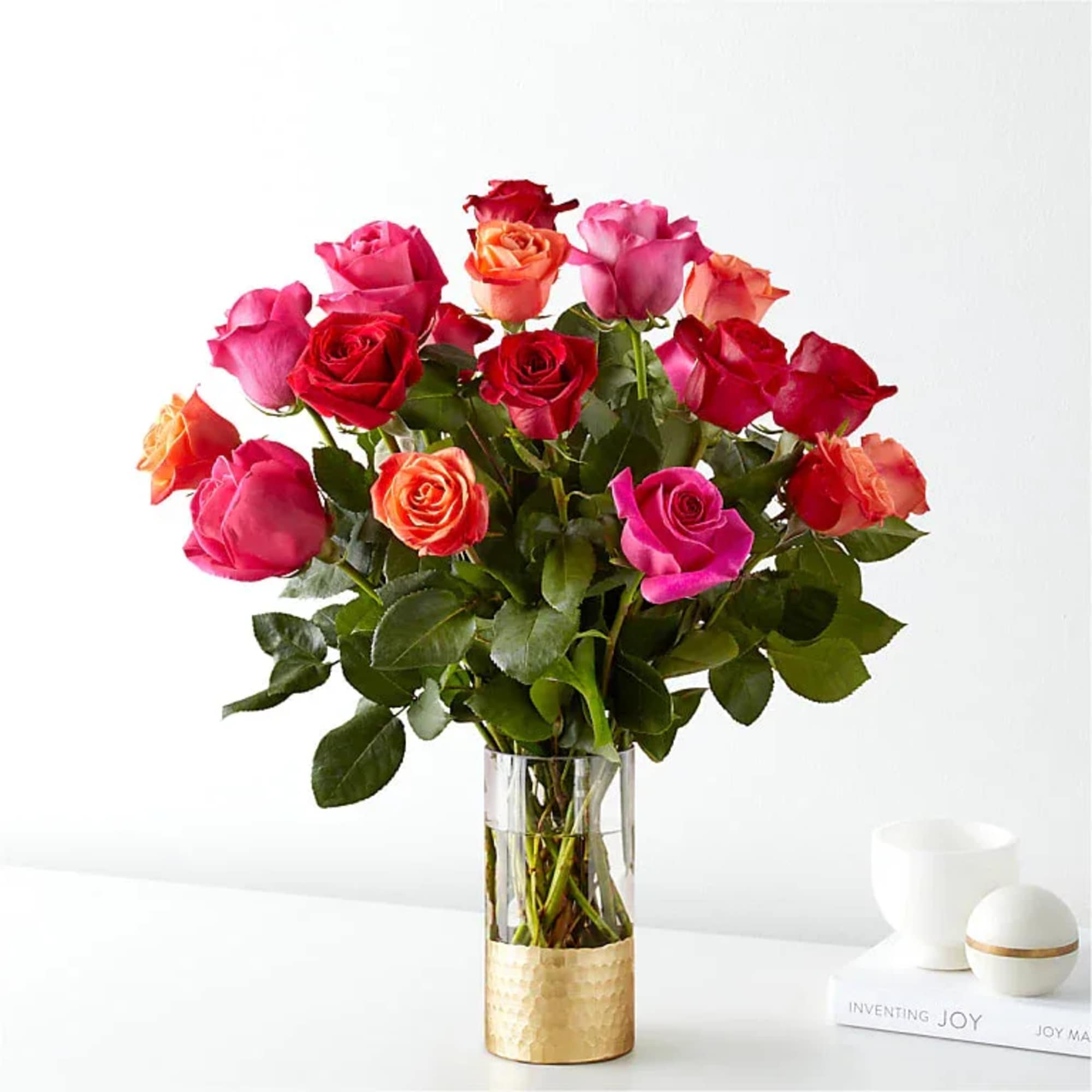 A lush cluster of roses in vivid pinks, reds, peaches and pops