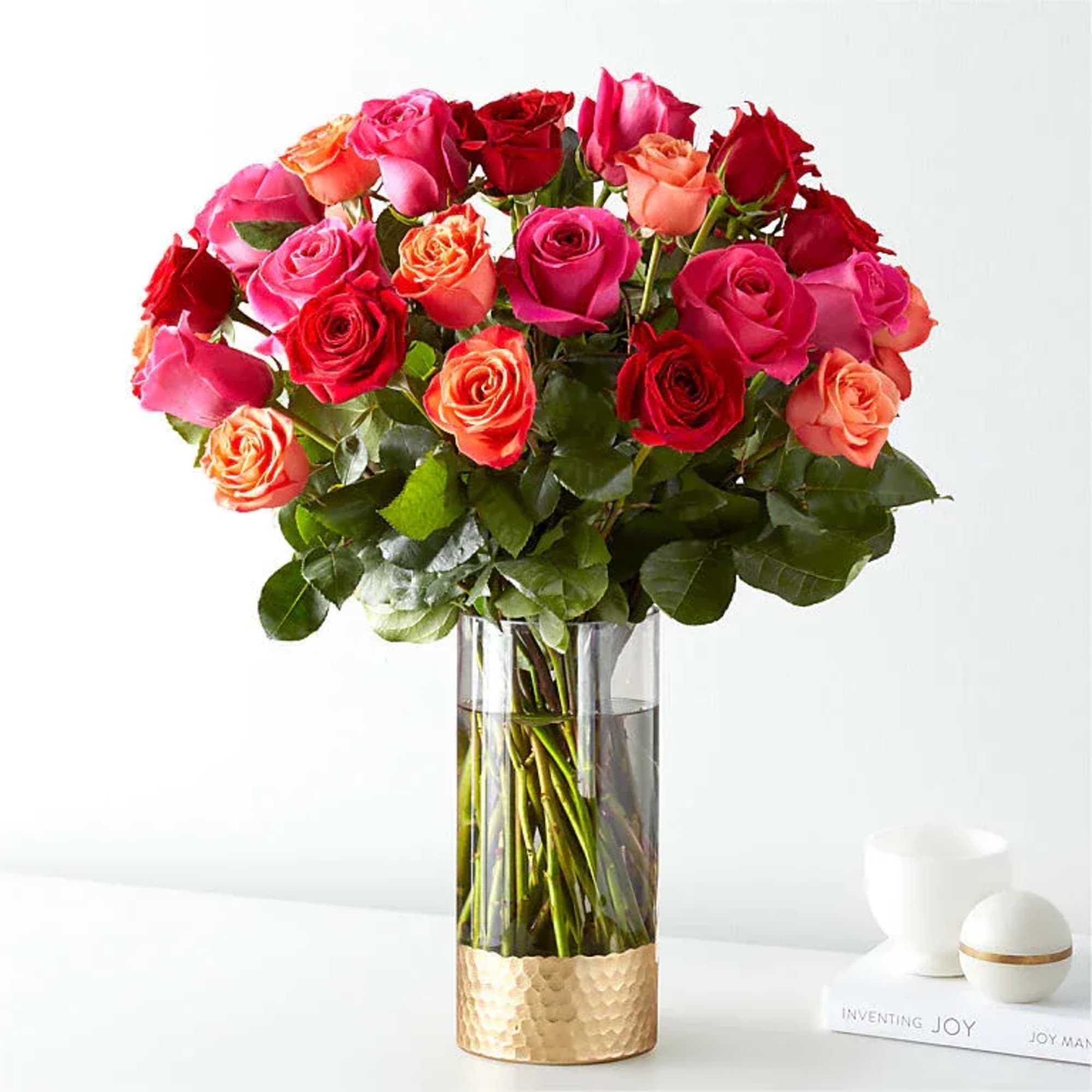 A lush cluster of roses in vivid pinks, reds, peaches and pops