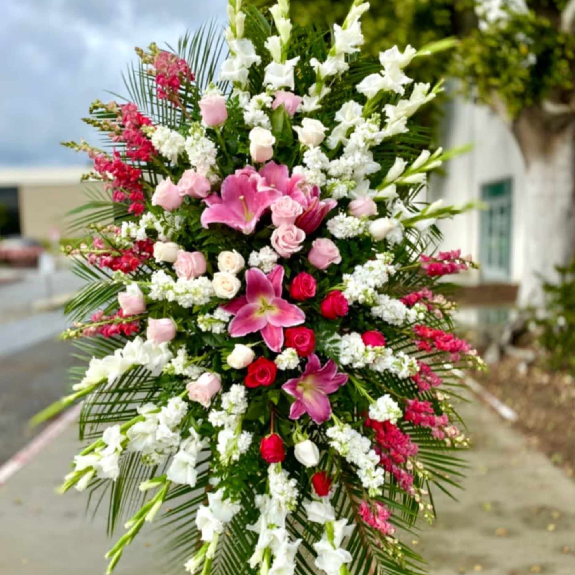 A tall, formal standing sympathy spray designed for funeral and memorial services