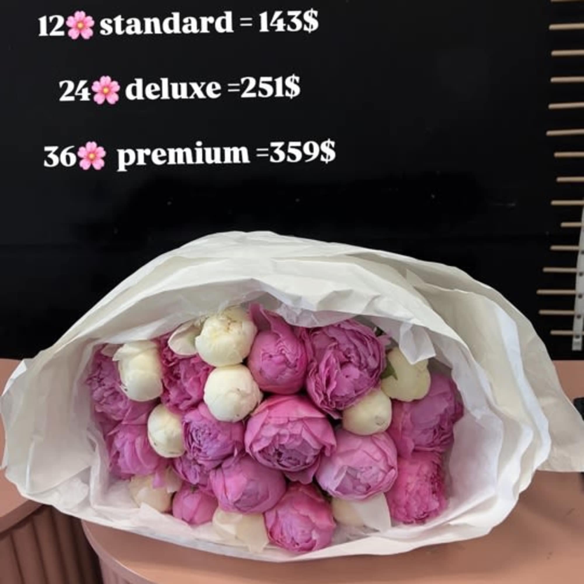 Bouquet of pink and white peonies wrapped in white paper