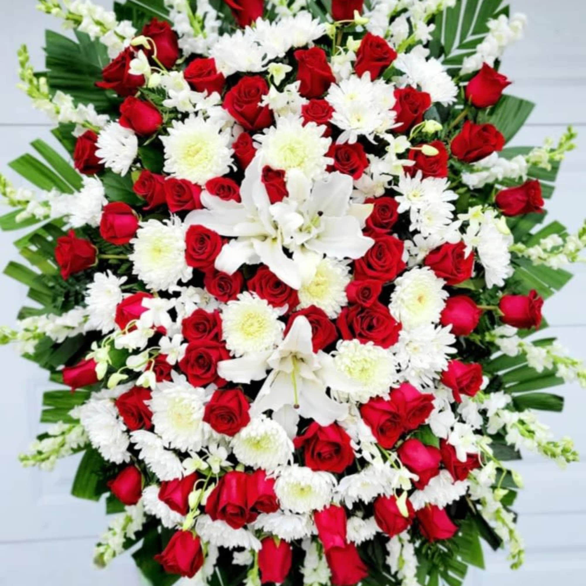 Dense clusters of two dozen red roses create a powerful, reverent focal