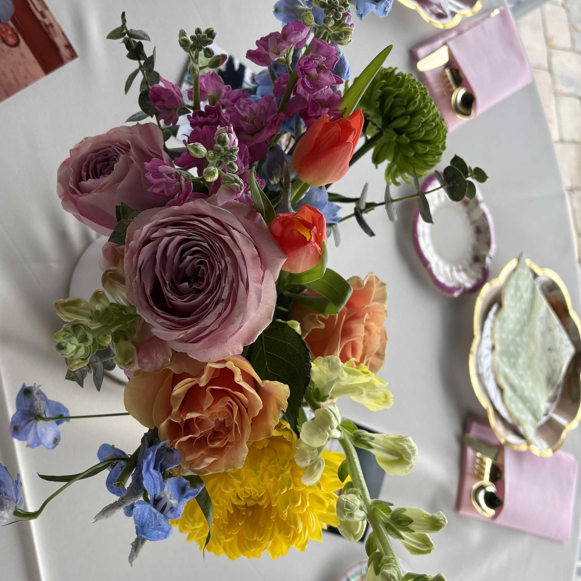 Colorful mixed bouquet with roses, tulips, and blue flowers