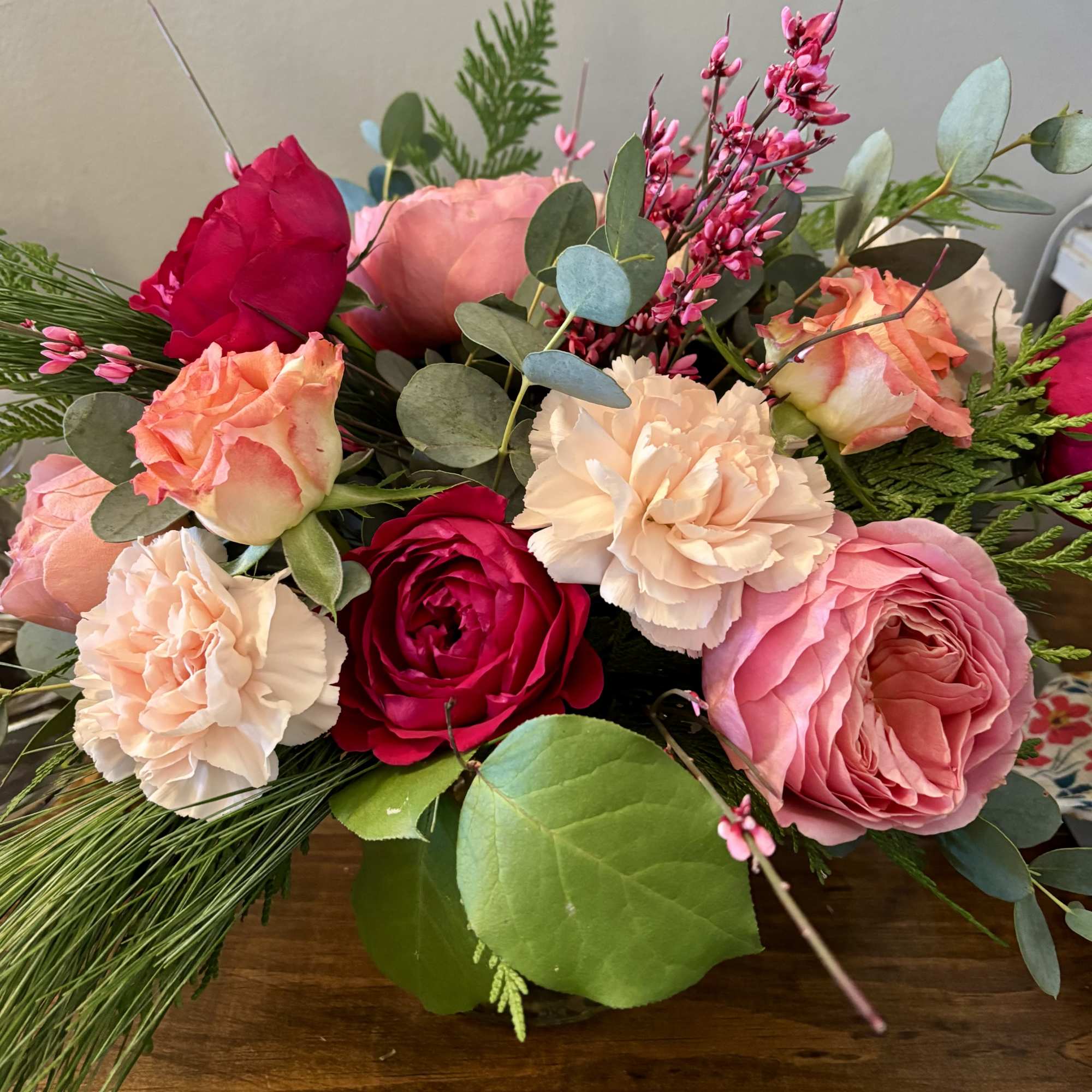 Mixed bouquet of pink and peach roses with carnations and greenery