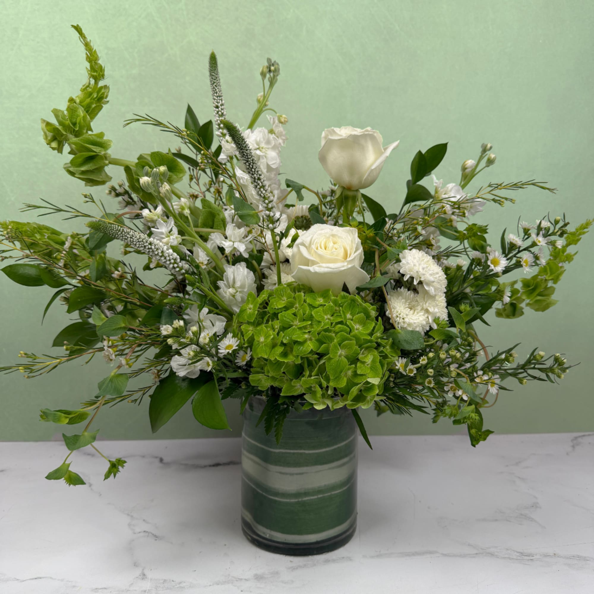 A crisp and elegant mix of white and green blooms designed to