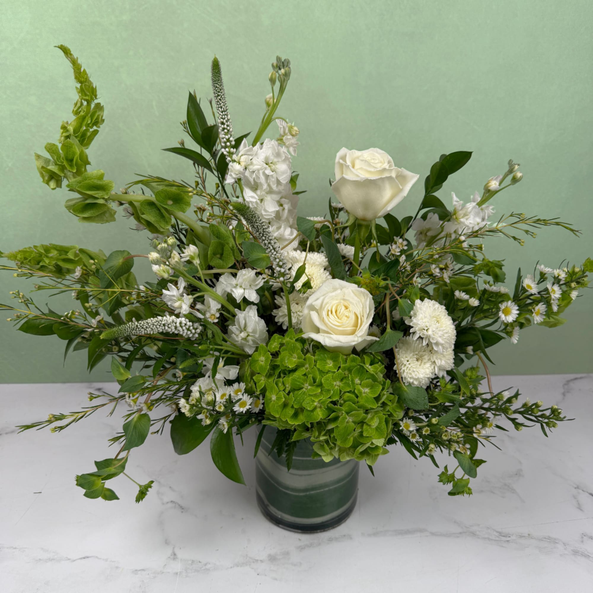A crisp and elegant mix of white and green blooms designed to