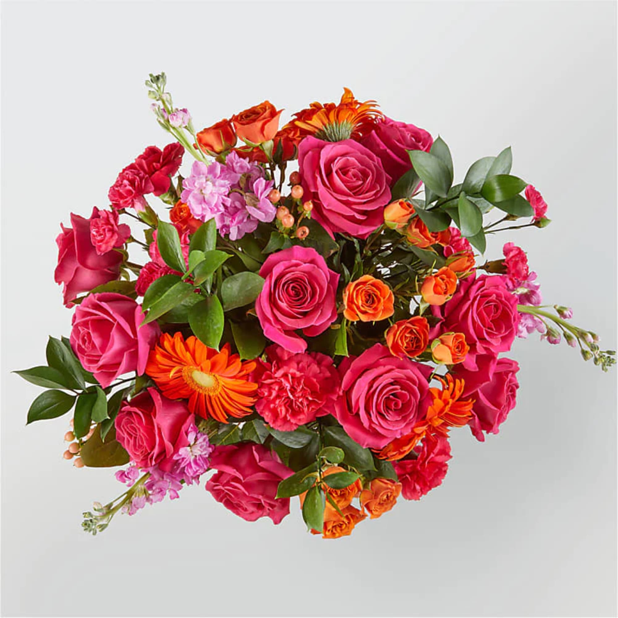 Bright bouquet of hot pink roses with orange blooms in a lush mixed arrangement