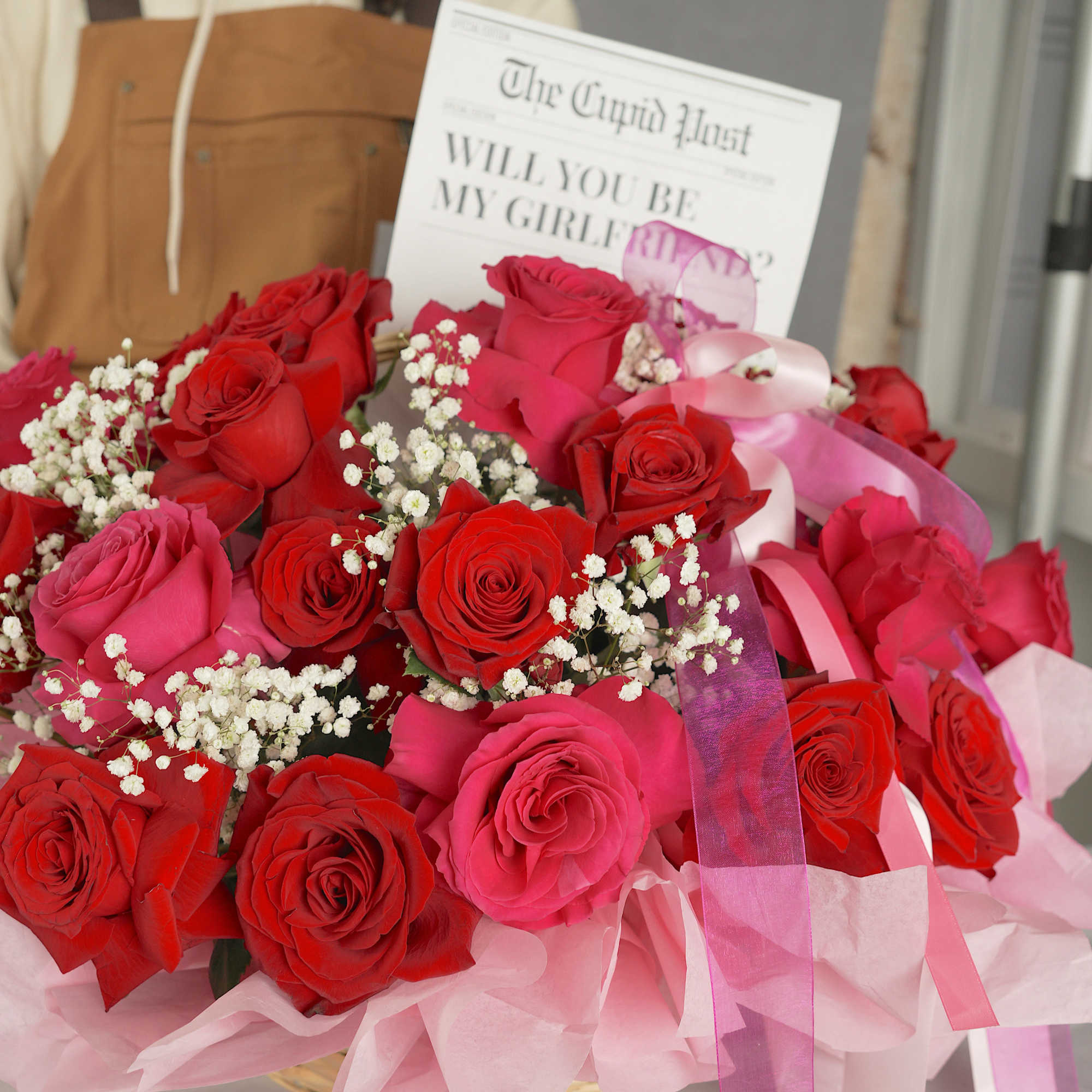 Bouquet of red and pink roses with baby's breath and ribbon