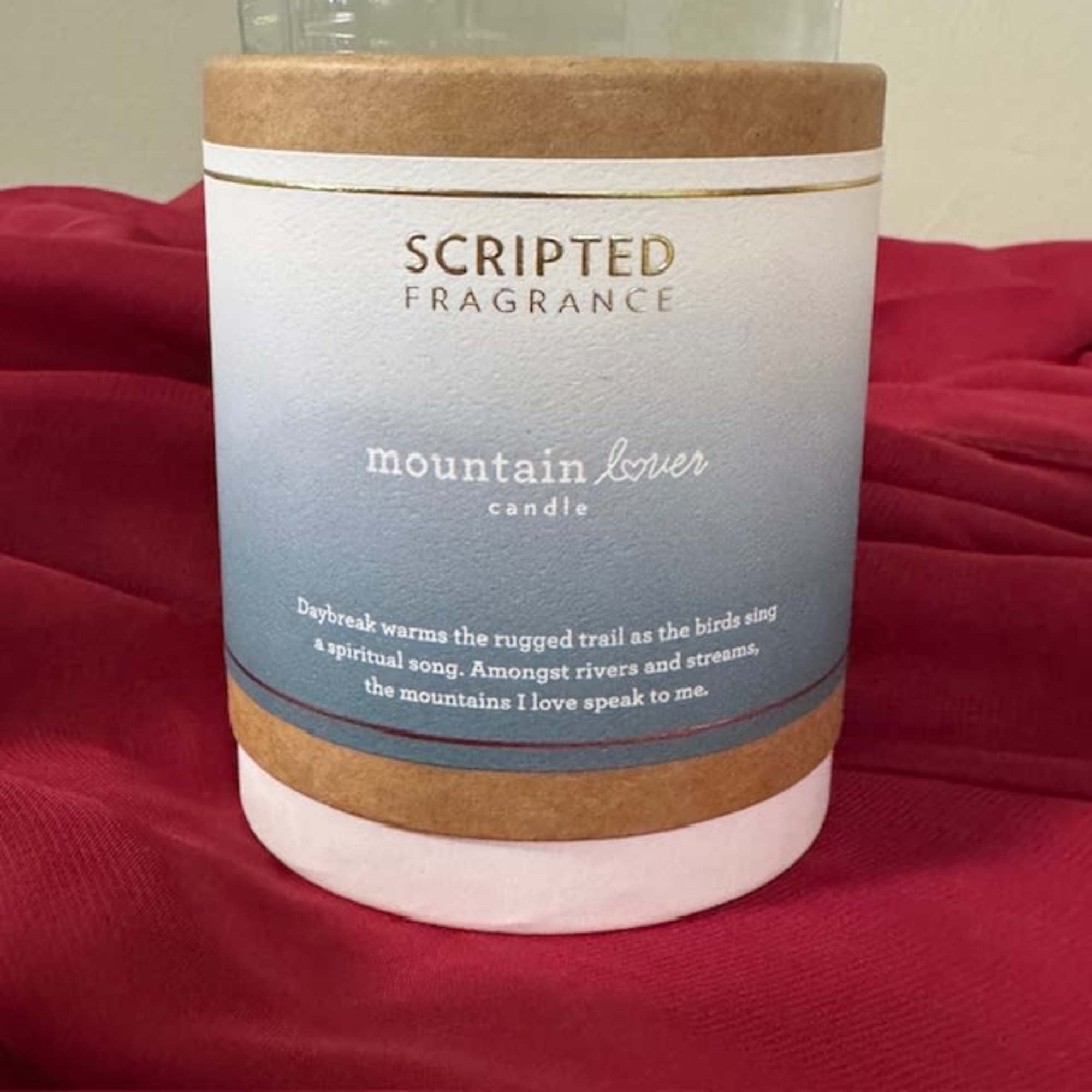 A scented candle in a cylindrical container with a printed label