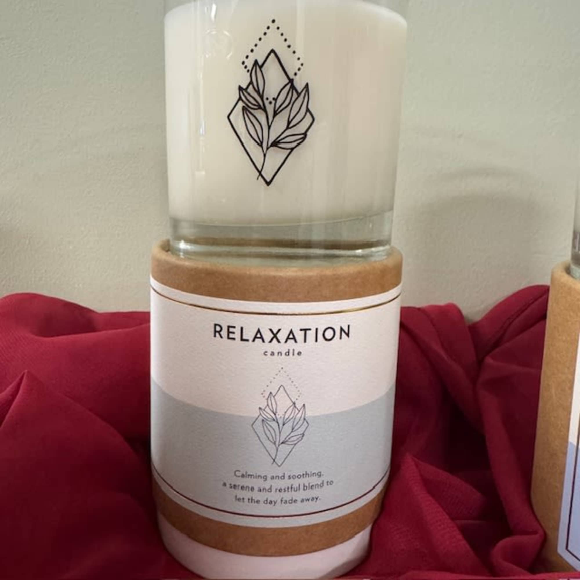 White relaxation candle in a glass jar with a tan label