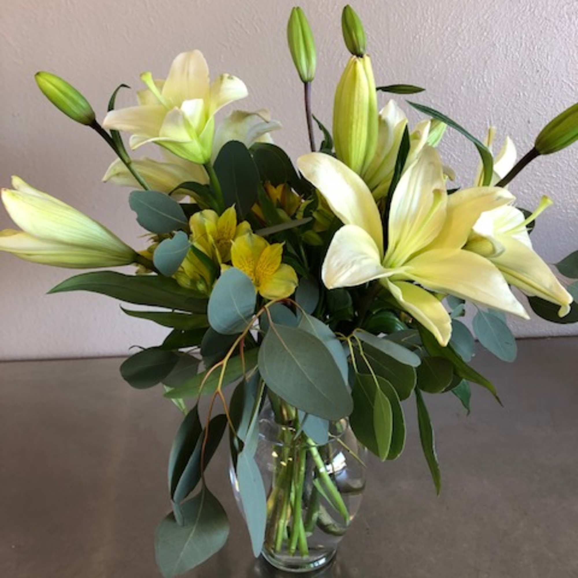 Brightly colored Asiatic lily (color may vary), complementary colored alstroemeria, and greenery
