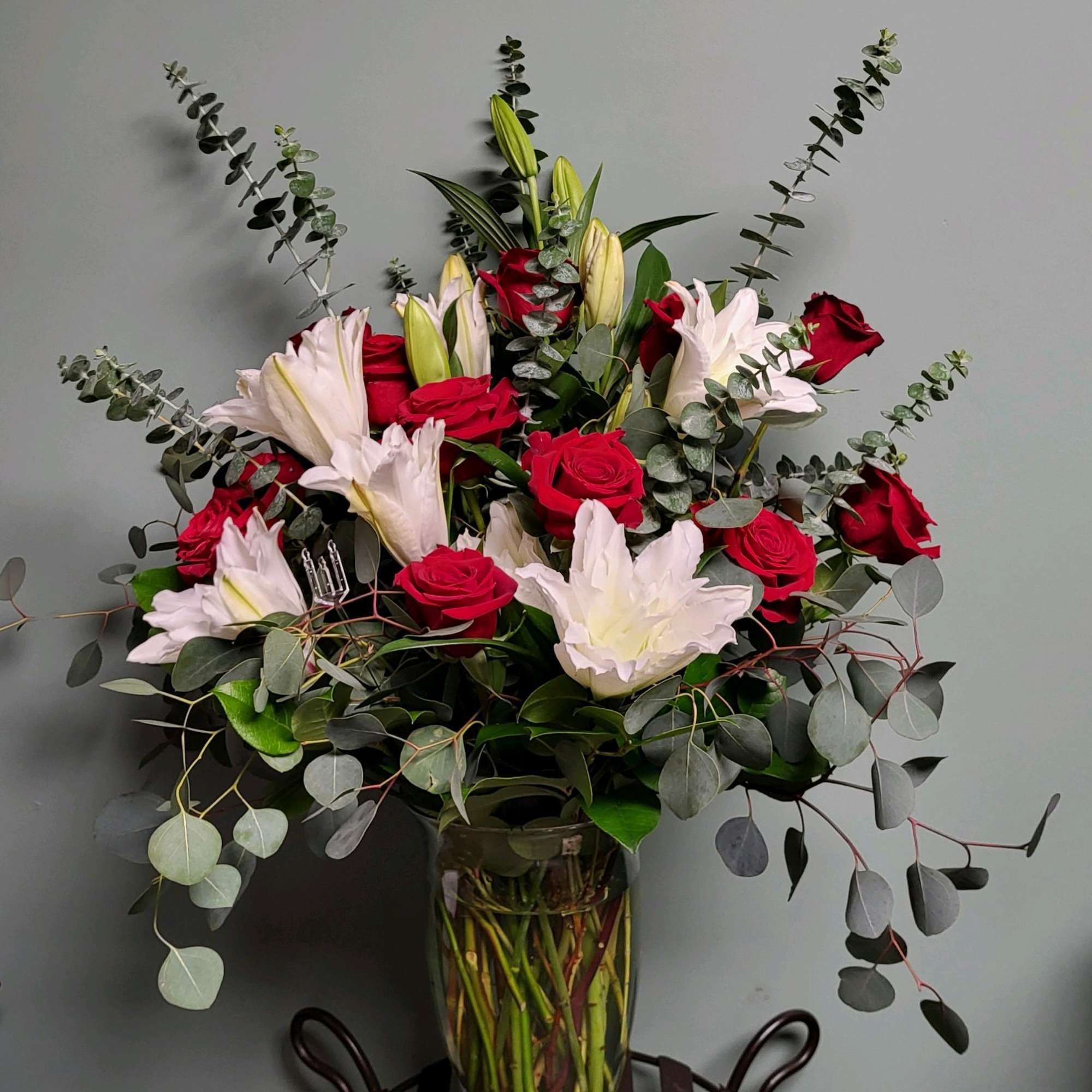 Bouquet of red roses and white lilies in a glass vase