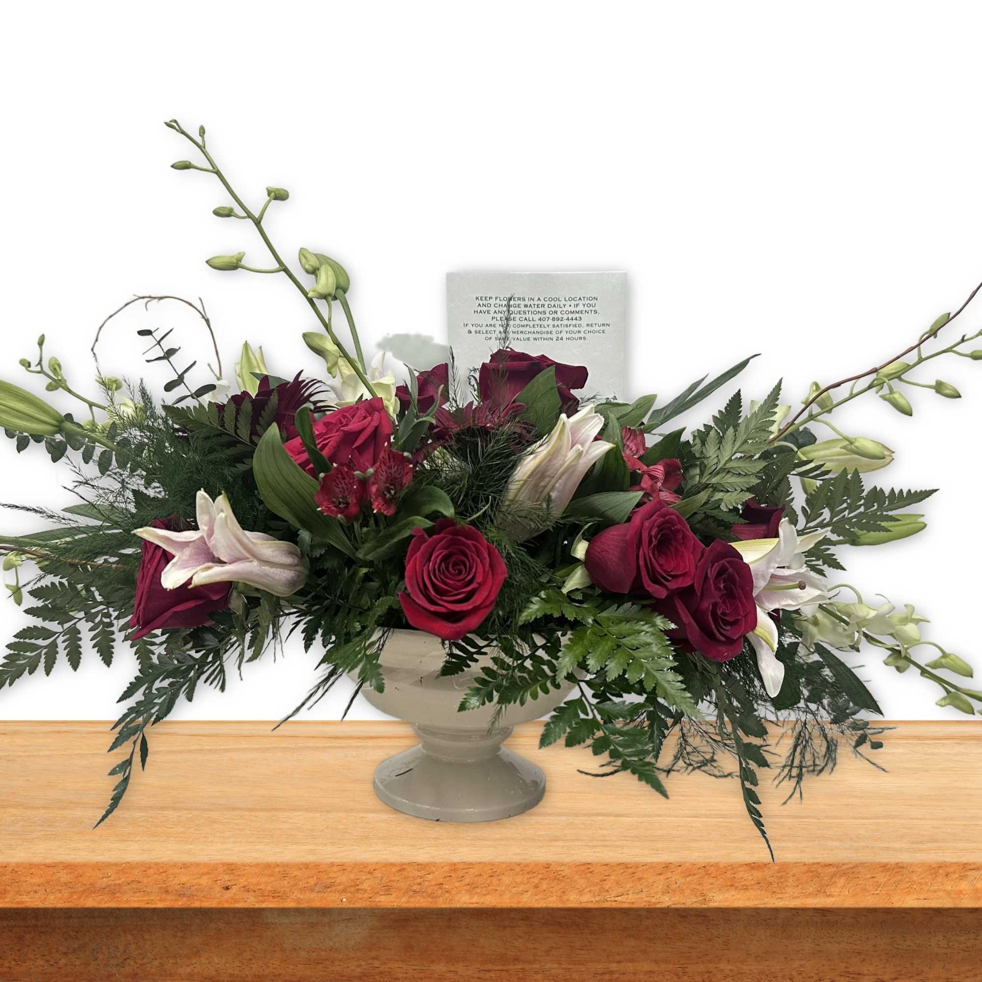 Long floral arrangement with red roses and white lilies in a pedestal vase
