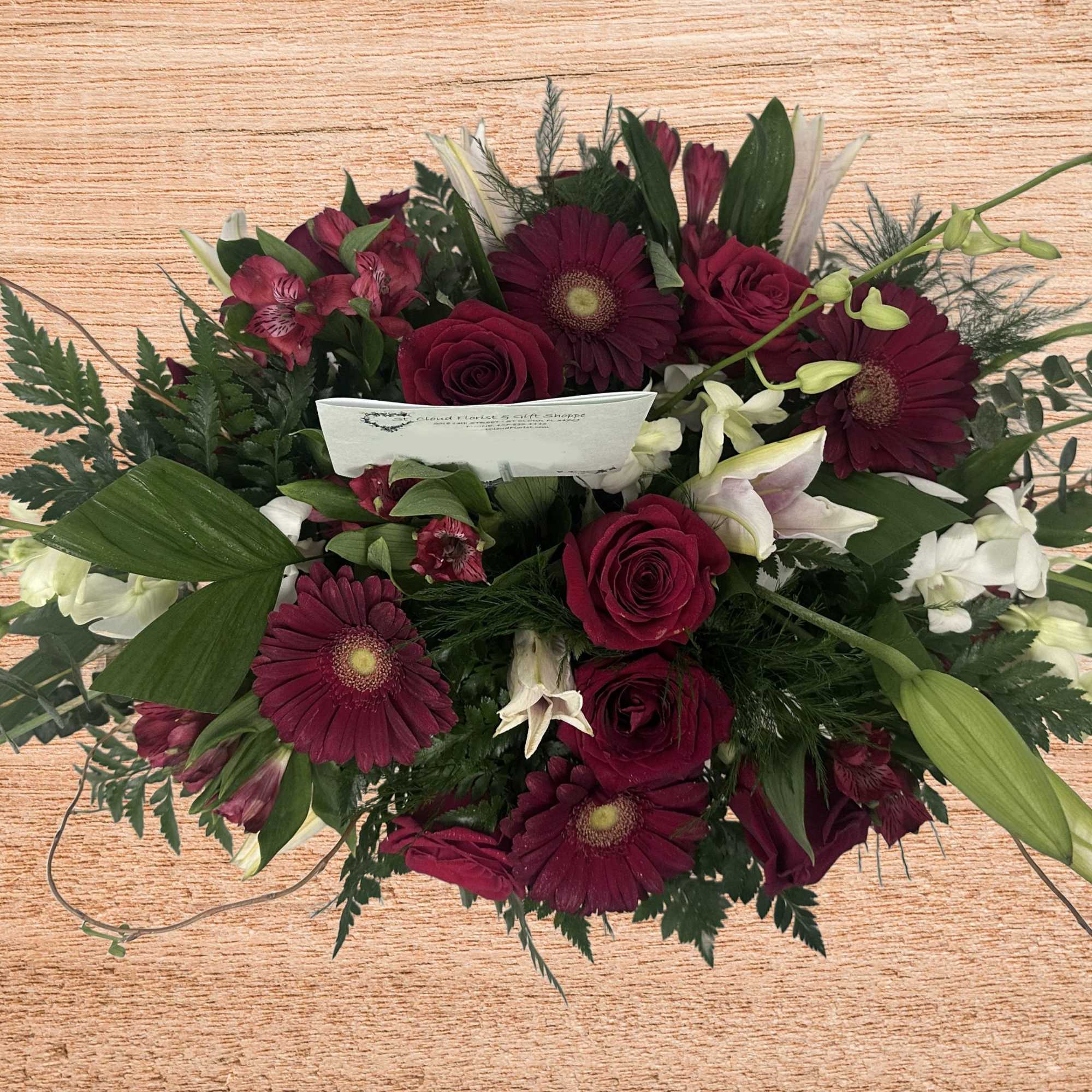 Bouquet of burgundy flowers with white lilies and green buds