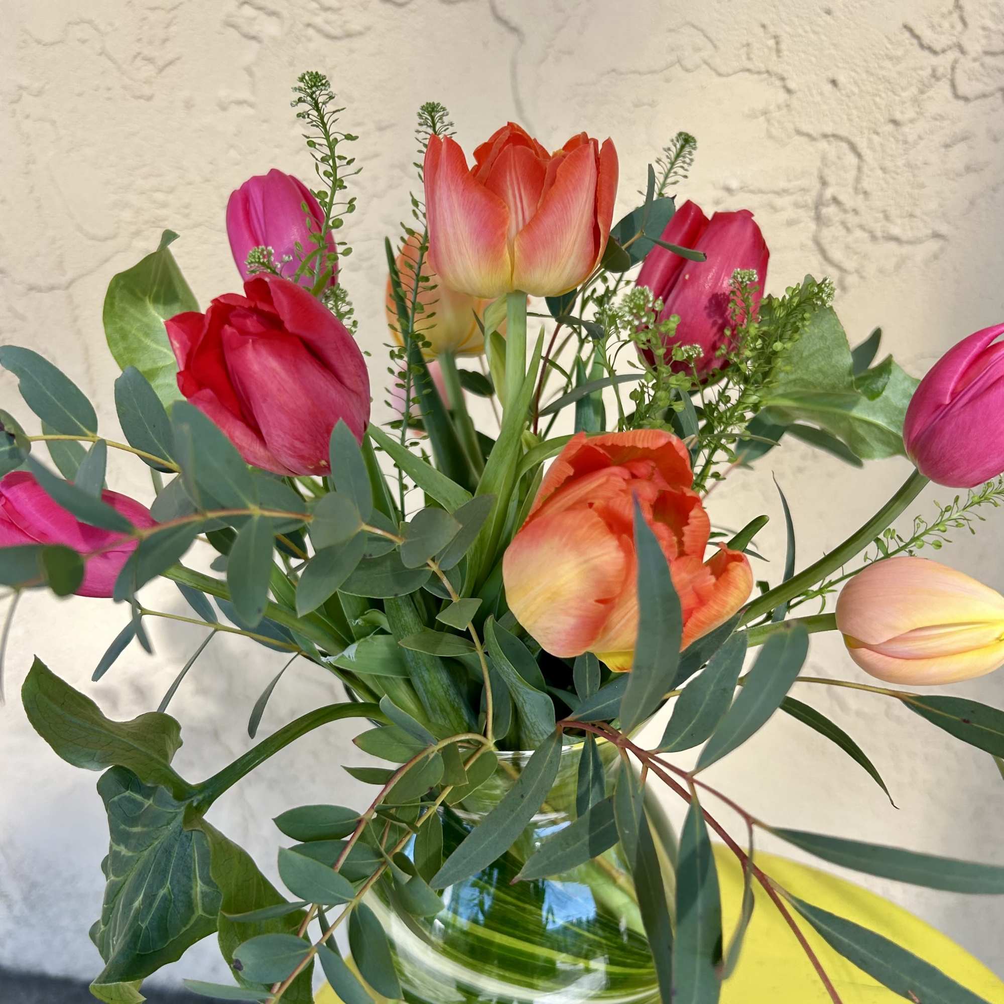 Bouquet of pink and orange tulips in a glass vase