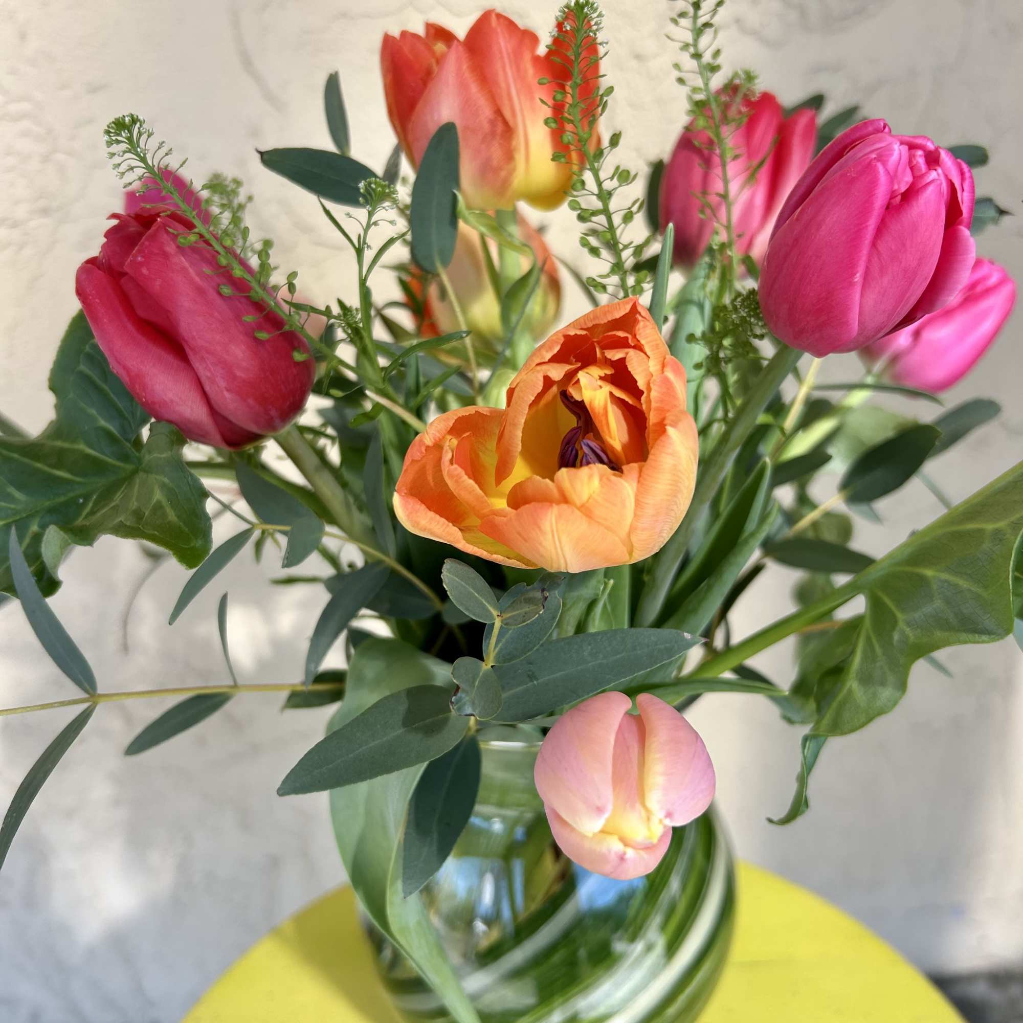 Bouquet of pink and orange tulips in a glass vase