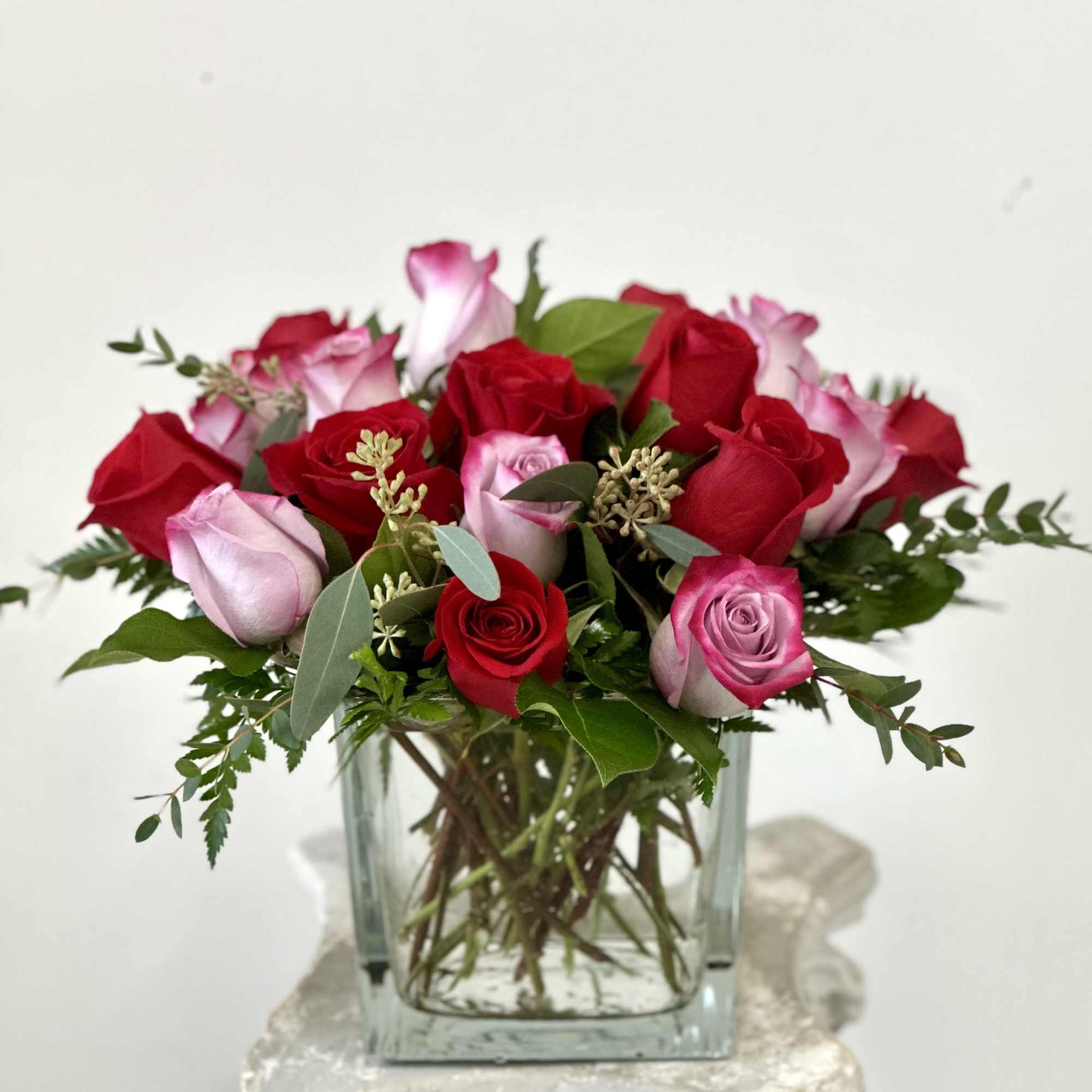 Bouquet of red and pink roses in a clear glass vase