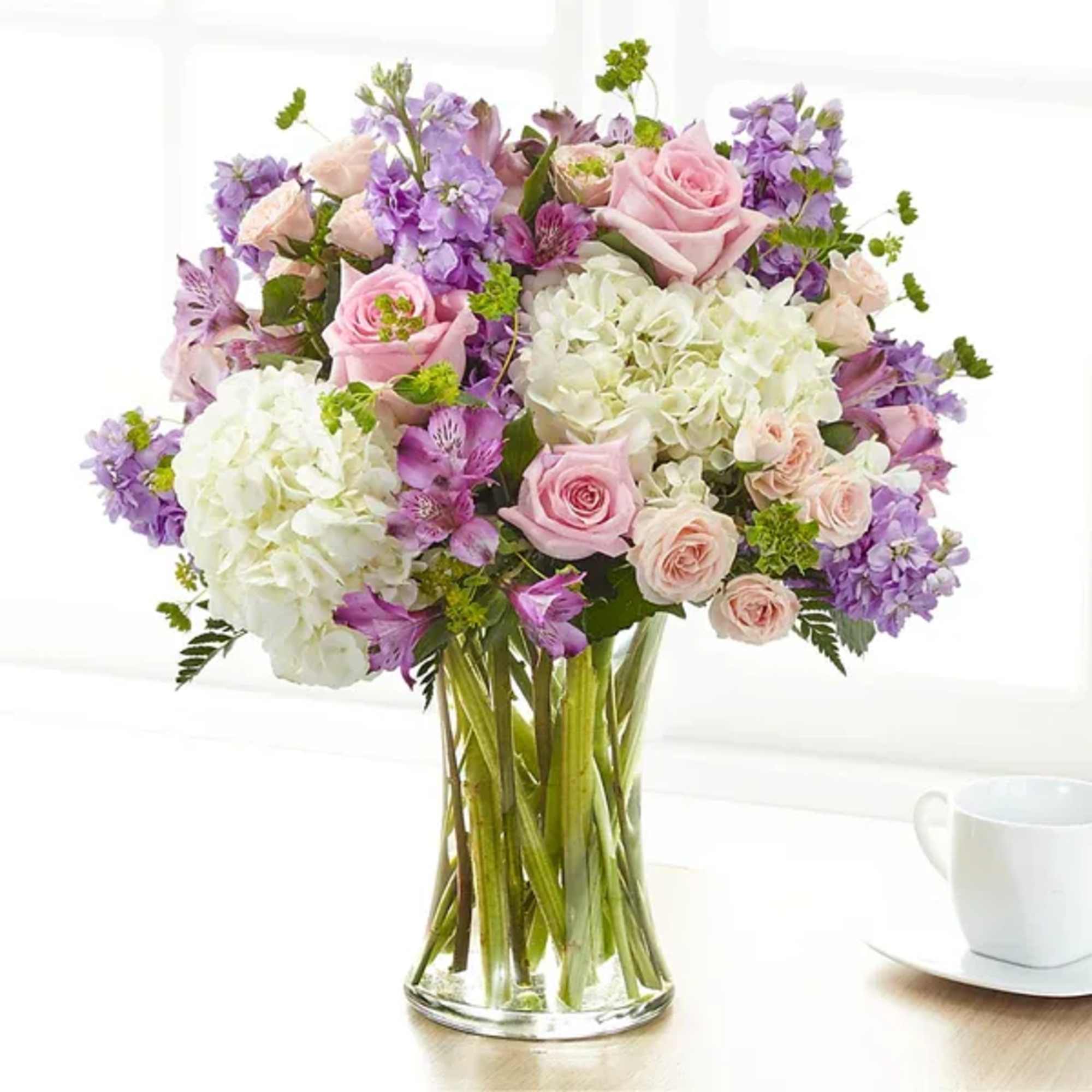 Bouquet of pink and purple flowers in a clear glass vase