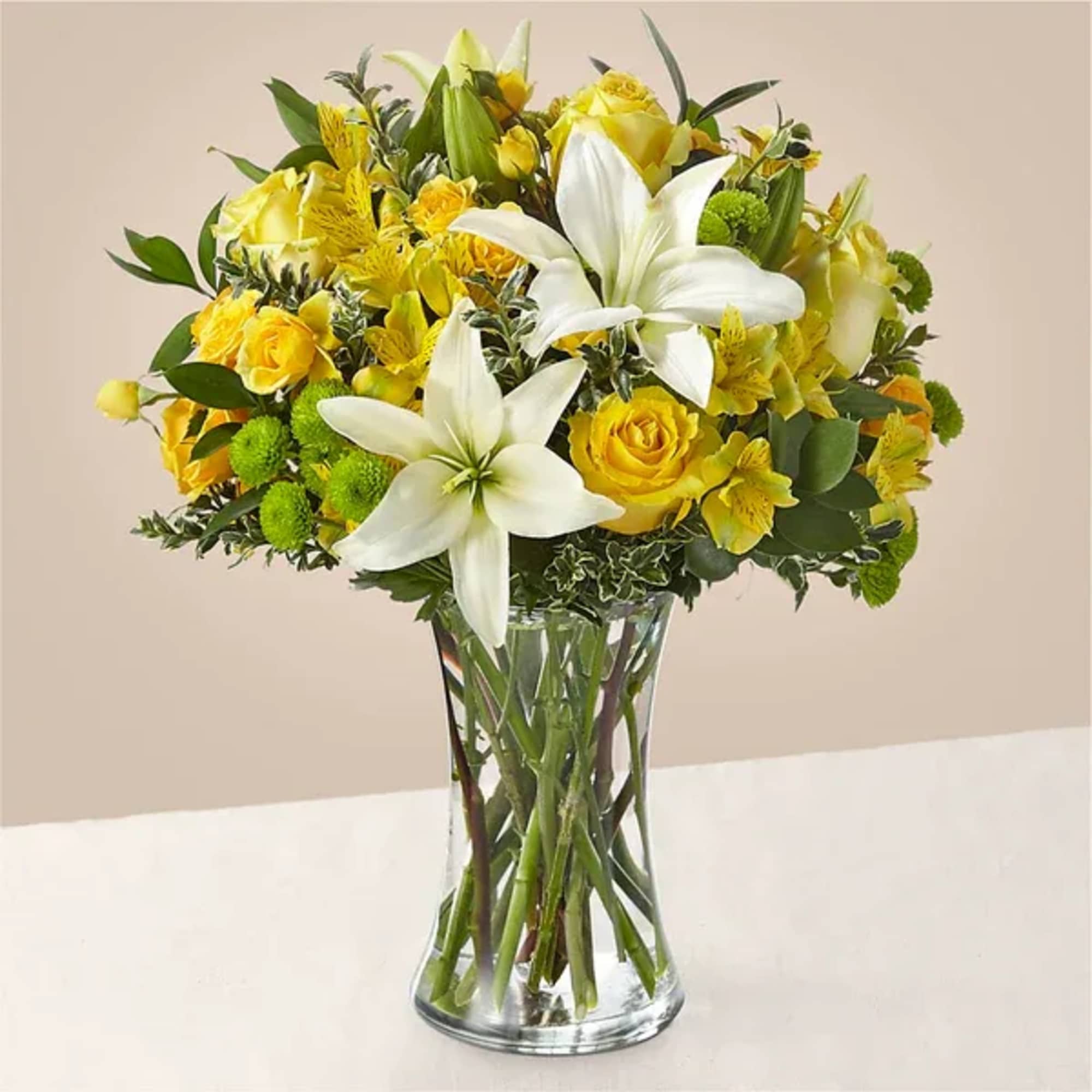 Yellow and white flower bouquet in a clear glass vase