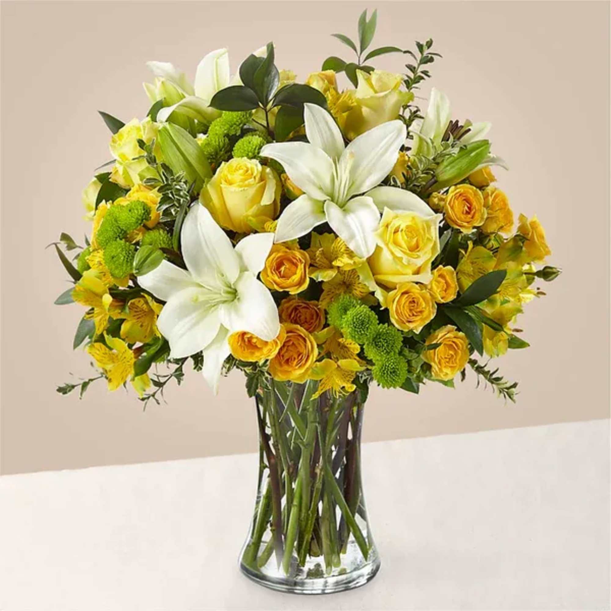 Yellow and white flower bouquet in a clear glass vase