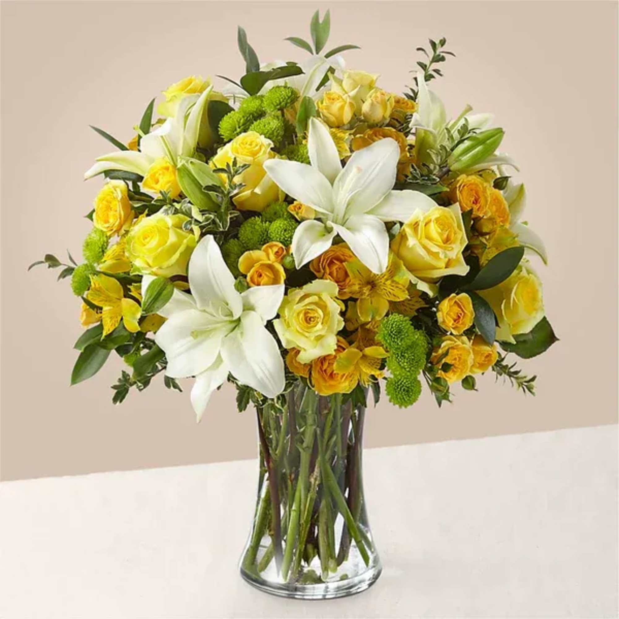 Yellow and white flower bouquet in a clear glass vase
