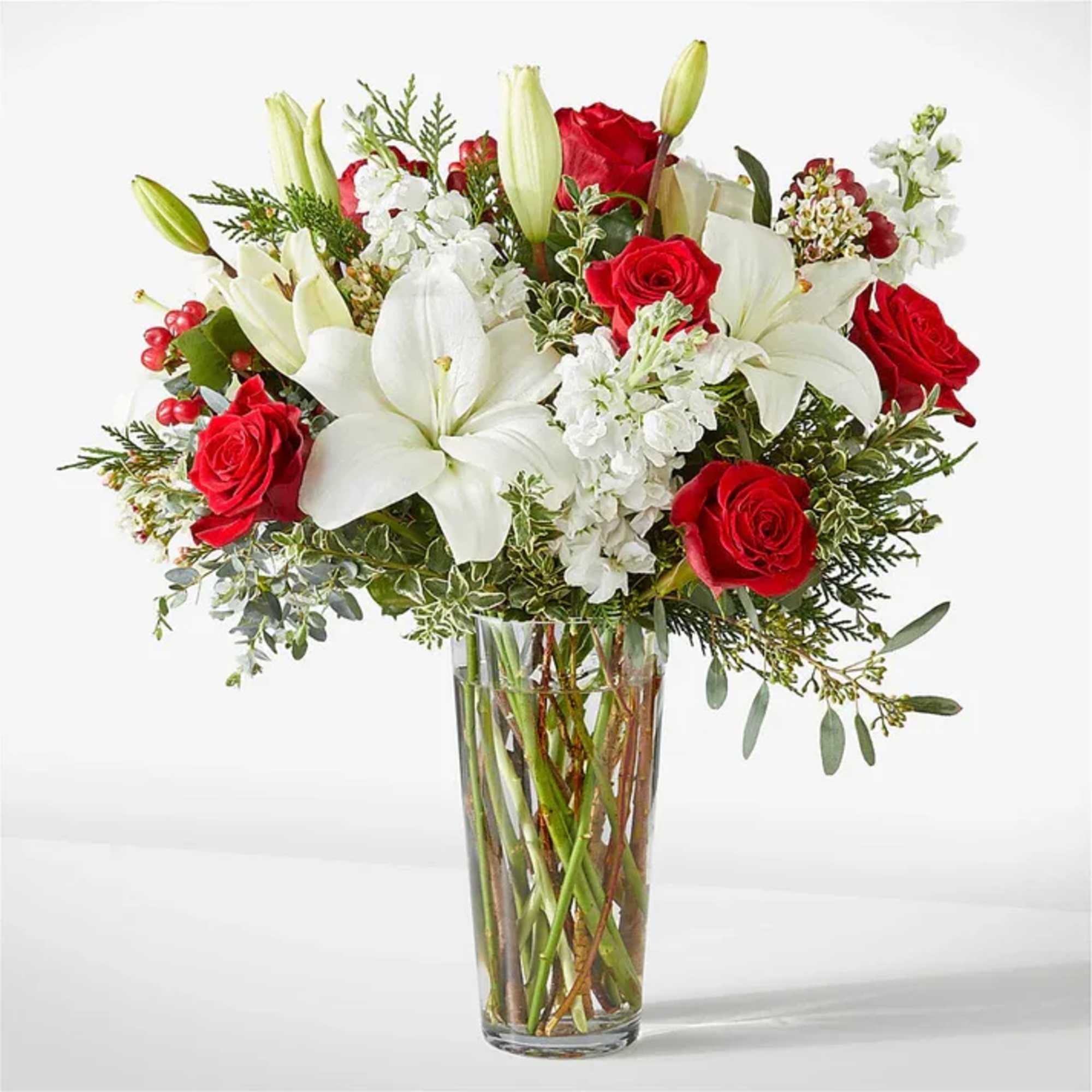 Red roses and white lilies in a clear glass vase
